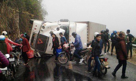 Xe container lat giua duong, de chet 2 nguoi hinh anh