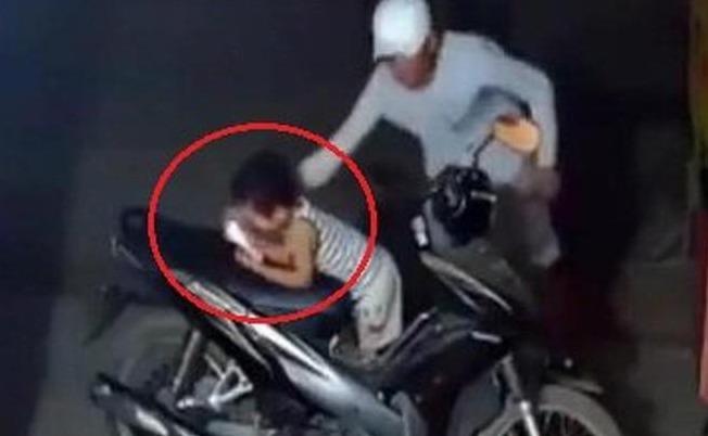 Cuop dien thoai tren tay chau be trong quan nuoc hinh anh