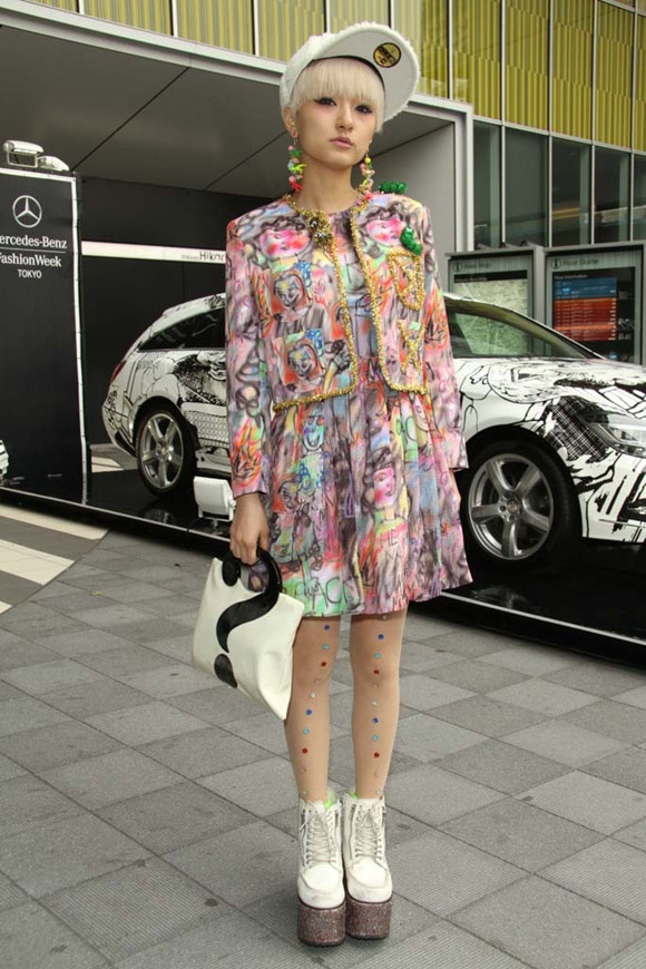  Váy và áo khoác mang kiểu dáng hơi hướng cổ điển nhưng đã được phá cách với nhiều họa tiết ngộ nghĩnh và màu sắc loang lổ, sặc sỡ. Phụ kiện giày, túi dấu hỏi rất độc, mũ và cả màu tóc với màu trắng tinh khôi phần nào trung hòa các gam màu.