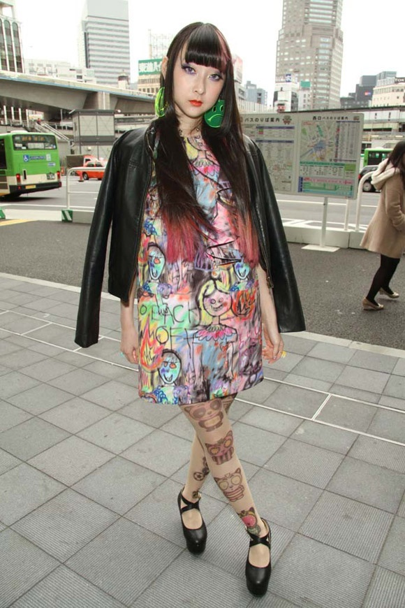 Vẫn là kiểu váy màu loang, họa tiết ngộ nghĩnh nhưng cô gái này lại tạo ra một vẻ thu hút bí ẩn. Đôi bông tai xanh lá to bản và đôi tất chân hình gấu trúc rất ấn tượng.