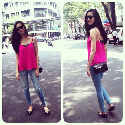 Thùy Dung cũng diện một chiếc áo hai dây tương tự như Yến Trang nhưng mang sắc hồng rất tươi tắn. Hoa hậu mix nó cùng quần jeans và giày bệt trẻ trung.