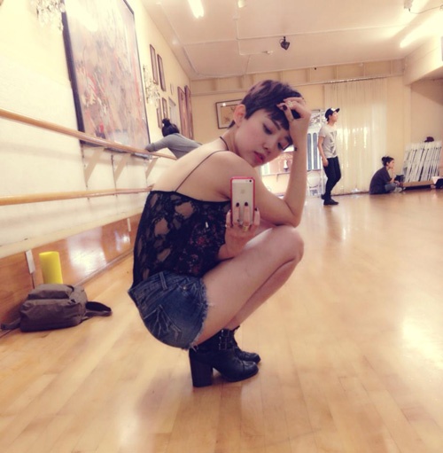 Cô kết hợp kiểu áo sexy này với quần soóc rách cá tính.