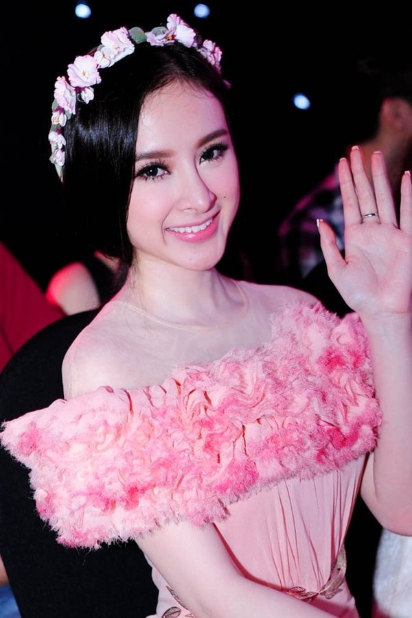 Angela Phương Trinh trong tâm thế của một người đẹp sắp đăng quang Hoa hậu khi để tóc búi thấp ôm trọn khuôn mặt trái xoan, tô điểm thêm cùng vòng hoa trên đầu.