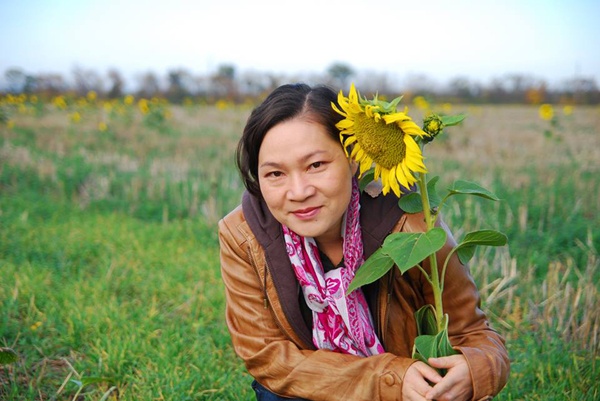 BTV Kim Ngân tạo dáng với hoa hướng dương.