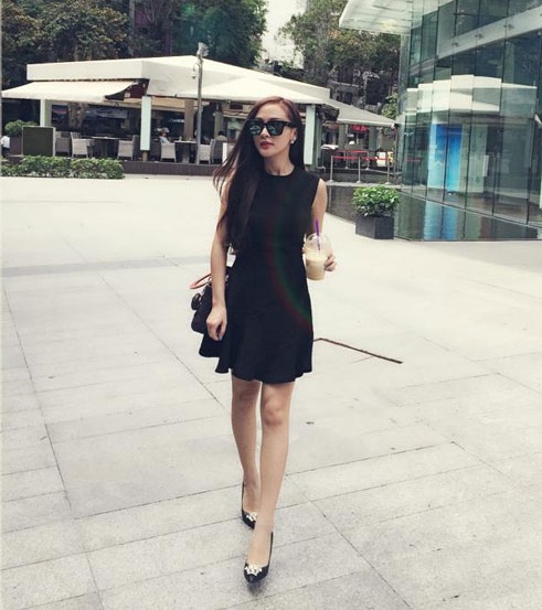 Thiết kế váy dáng ngắn trẻ trung, đơn giản Kelly Tú Anh không hề  bị già dù diện cả cây đen xuống phố. 