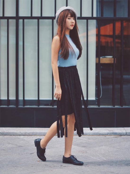 Quỳnh Anh Shin sành điệu và ấn tượng khi chọn diện chân váy tua rua  xuống phố.  Giày oxford, mũ nồi là những phụ kiện lên ngôi  trong mùa mới được cô nàng chọn để mix cùng.
