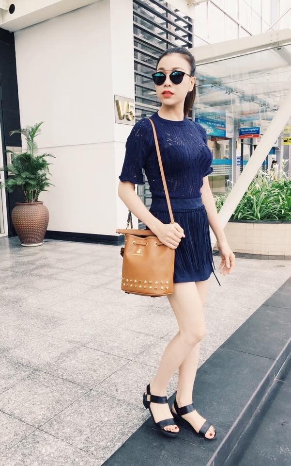 Quỳnh Nga đẹp dịu dàng với chân váy caro và áo chất liệu mềm mại.  Đôi giày và túi xách được cô nàng khéo kết hợp cùng tông với nhau.