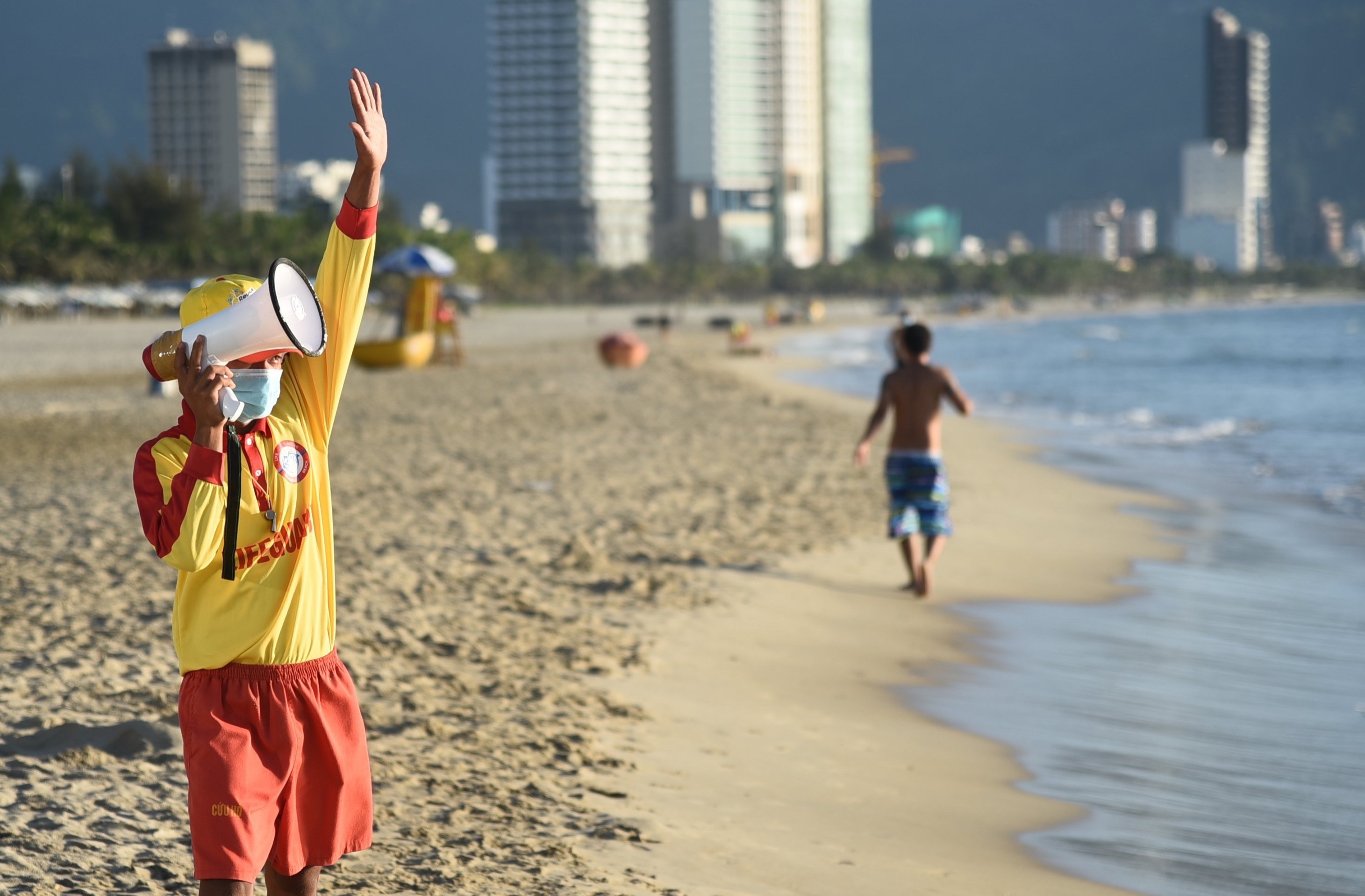 Bai bien Da Nang vang ve, nguoi dan deo khau trang tap the duc hinh anh