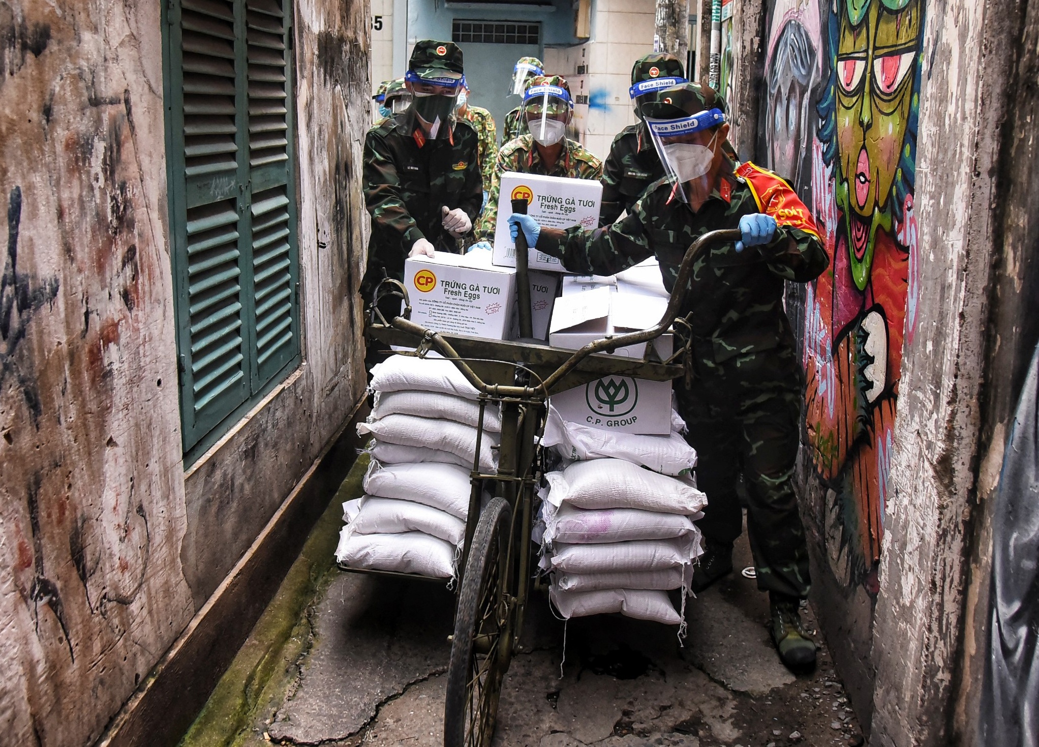 Bo doi dung xe dap tho dua thuc pham vao ngo hem TP.HCM hinh anh