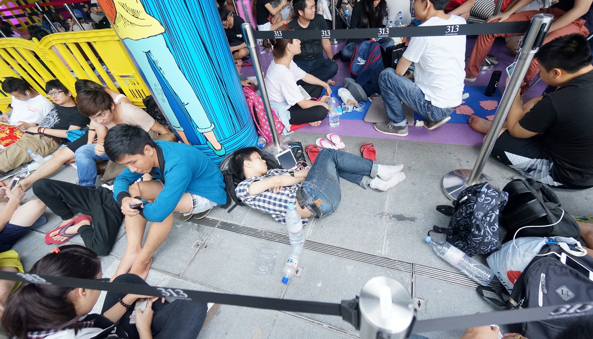 Nhiều du học sinh và nhân viên cửa hàng tập trung trước một điểm bán ở Singapore trong đợt bán iPhone 6 năm ngoái. Họ phải trải qua nhiều giờ ăn ngủ vạ vật để tranh suất mua iPhone. Ảnh: Duy Tín.