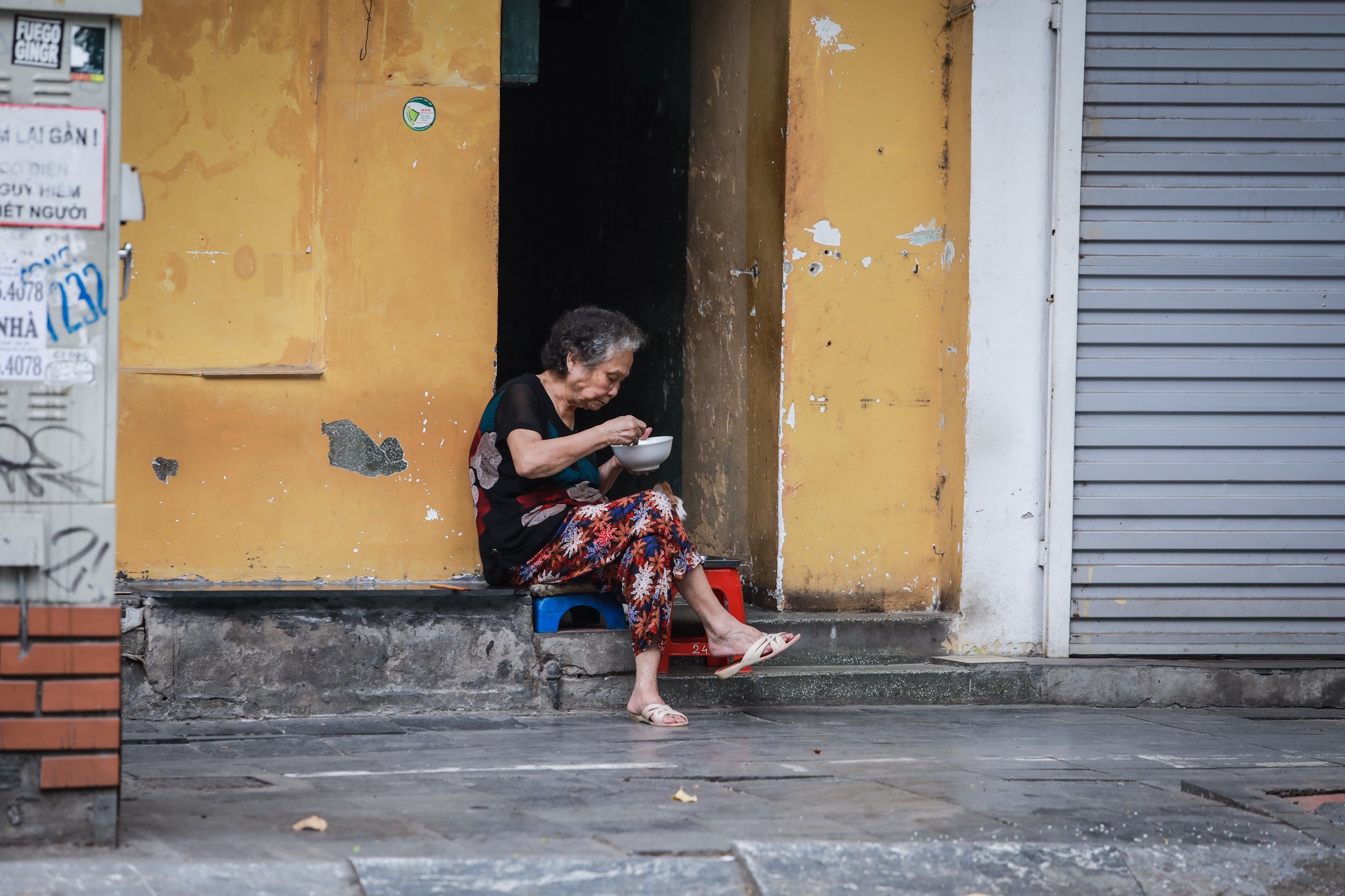 Nguoi dan ngoi an sang truoc cua nha vi cua hang an dong cua mua dich anh 3