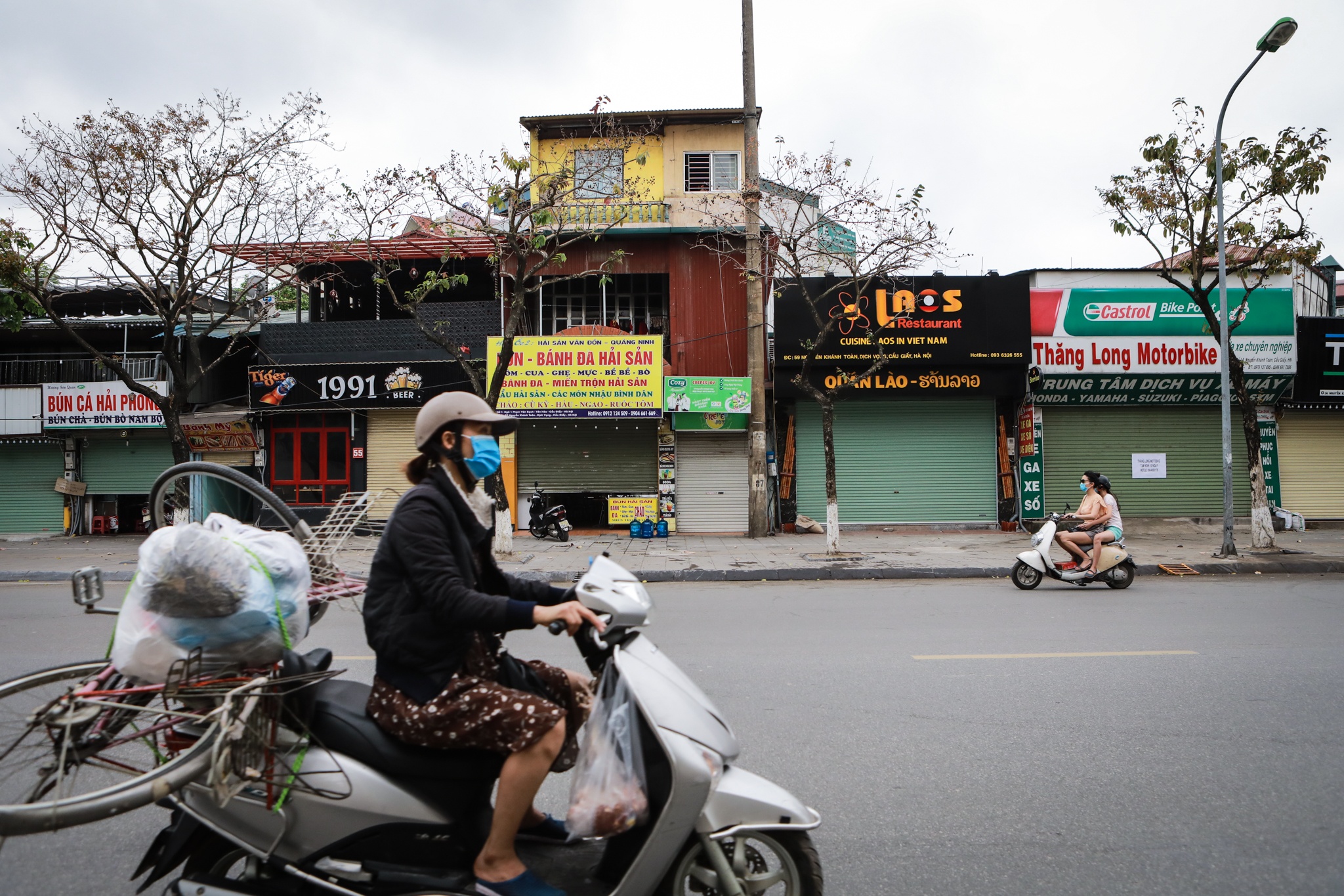 Nguoi dan ngoi an sang truoc cua nha vi cua hang an dong cua mua dich anh 1