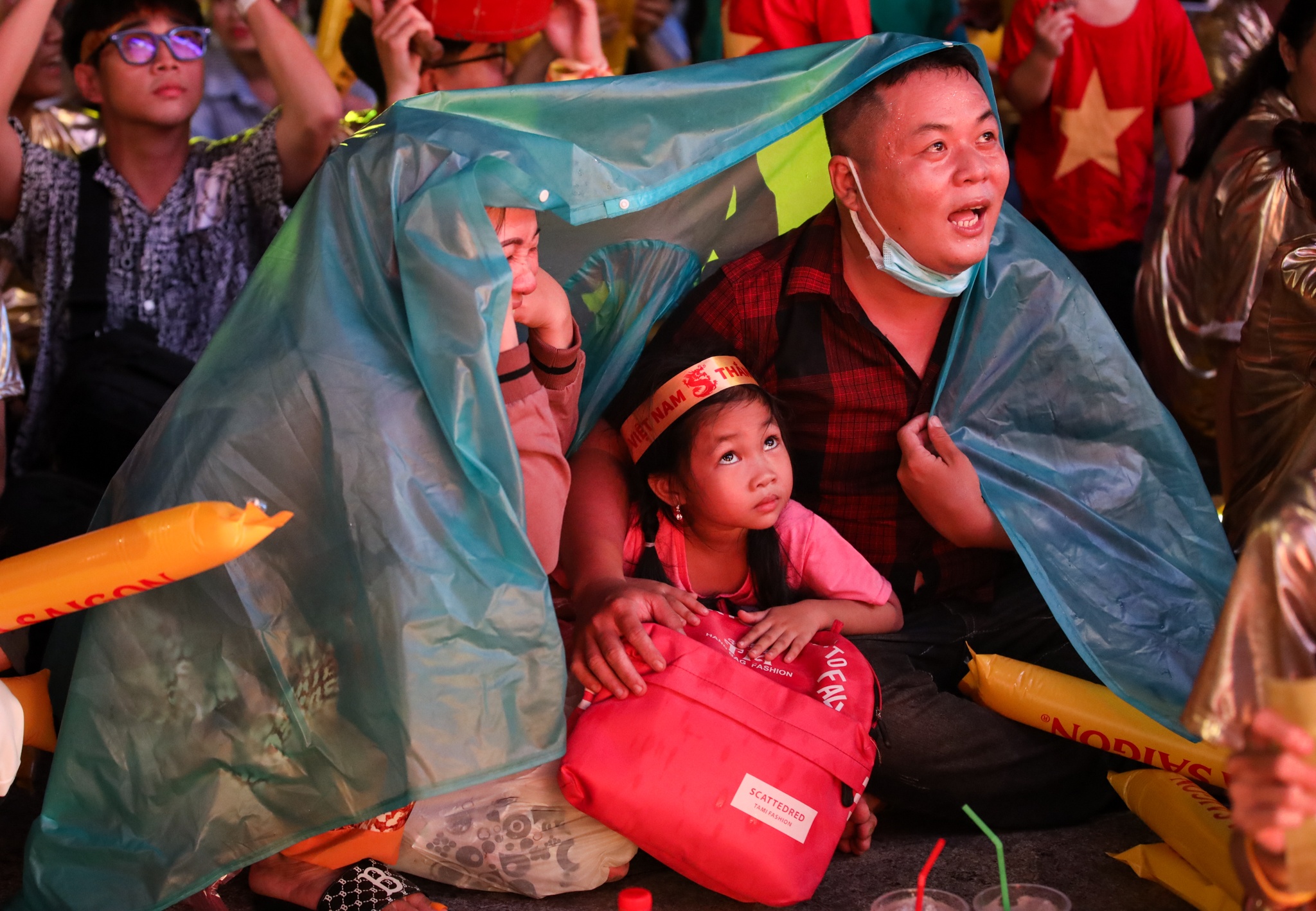 Cổ động viên đội mưa xem bóng đá ở phố đi bộ Nguyễn Huệ ảnh 5 Co dong vien doi mua xem bong da o pho di bo Nguyen Hue anh 5