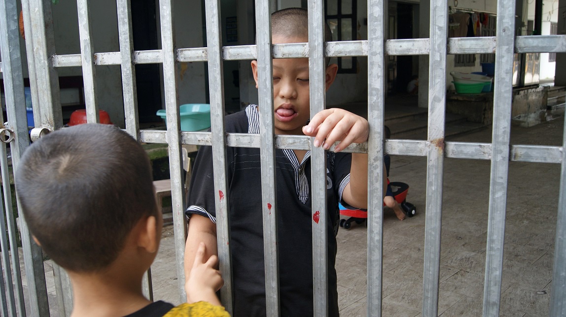 Mọi hôm, 2 đứa trẻ này được chơi với nhau nhưng hôm nay do kẻ trong, người ngoài (trẻ phía ngoài ra khỏi cổng trước khi có phóng viên đến) nên chúng chỉ còn biết quyến luyến nhau qua cổng sắt.