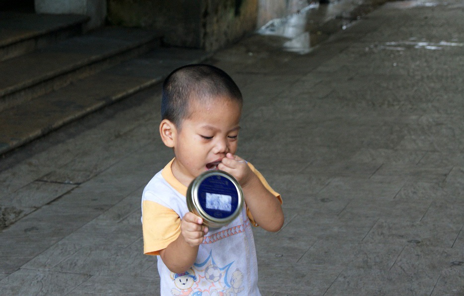 Một cậu bé lang thang trong sân và tìm cách vét lại những gì còn bỏ sót trong hộp thịt. 