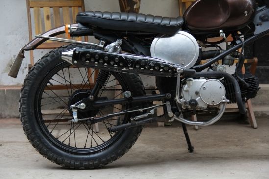 Giải quyết được phần động cơ để đảm bảo cho người sử dụng có thể thoải mái khi vận hành xe, chúng ta sẽ tìm hiểu tiếp đến phần cấu trúc xe. Phần này vẫn sử dụng toàn bộ hệ khung của Win do nó đáp ứng đủ yêu cầu cơ bản, mang đặc trưng của Scrambler. Phần càng trước sau vẫn giữ nguyên thông số chiều dài nguyên bản, song đều phải thay mới vì bộ càng cũ đã xuống cấp. Thay đổi lớn nhất về kết cấu đó là bộ vành bánh được thay bằng vành 18, yếu tố tạo thành Scrambler. Bánh trước 300-18, bánh sau 350-18 đều là loại lốp gai vuông, mà dân chơi xe thường gọi là “gai chân chó” của cao su Sao Vàng. Tay lái cũng là phần quan trọng trong kết cấu tổng thể của xe và cần đáp ứng đủ những yếu tố để phù hợp và dễ dàng điều khiển cho người lái. Ghi đông Minsk đã đáp ứng yêu cầu đó. Hơn nữa, nó lại rất nhỏ gọn, thuận tiện dễ kiểm soát khi chạy trong phố cũng như chạy đường khó.