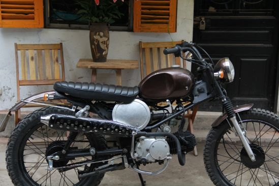 Thoáng qua về phần ngoại hình mẫu Scrambler nữ này, chúng ta dễ dàng nhận thấy những đường nét uyển chuyển, căng tròn và mềm mại như thân thể mặn mà của phụ nữ tới thì. Với bình xăng giọt nước được gò nặn bằng tay, điểm nhấn nổi bật đầy sexy nóng bỏng thể hiện thái độ khác biệt giữa những gã đàn ông ngơ ngác đang bận thắc mắc khi chiếc xe xuất hiện trên đường. Thêm một chi tiết khác không thể thiếu, nhấn mạnh vào đường nét Scrambler cổ điển từ những năm 1960 mà người làm xe muốn truyền đạt qua “tác phẩm này” là tấm cover ở hai bên thân xe, vừa để trang trí, vừa để bảo vệ cho ắc quy và bộ điện bên trong thân xe.