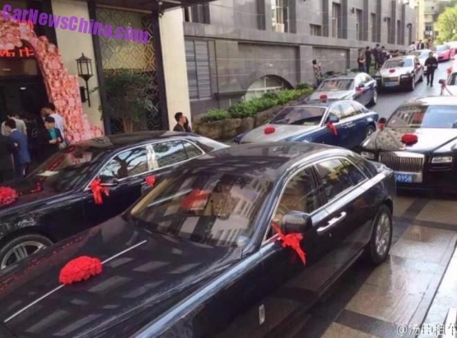 Những mẫu sedan siêu sang mang thương hiệu Rolls-Royce xếp hàng dài trên con phố nhỏ. Tất cả đều buộc nơ trên gương chiếu hậu. Có ít nhất 5 chiếc Rolls-Royce Ghost và một chiếc Bentley Mulsanne bên cạnh. 
