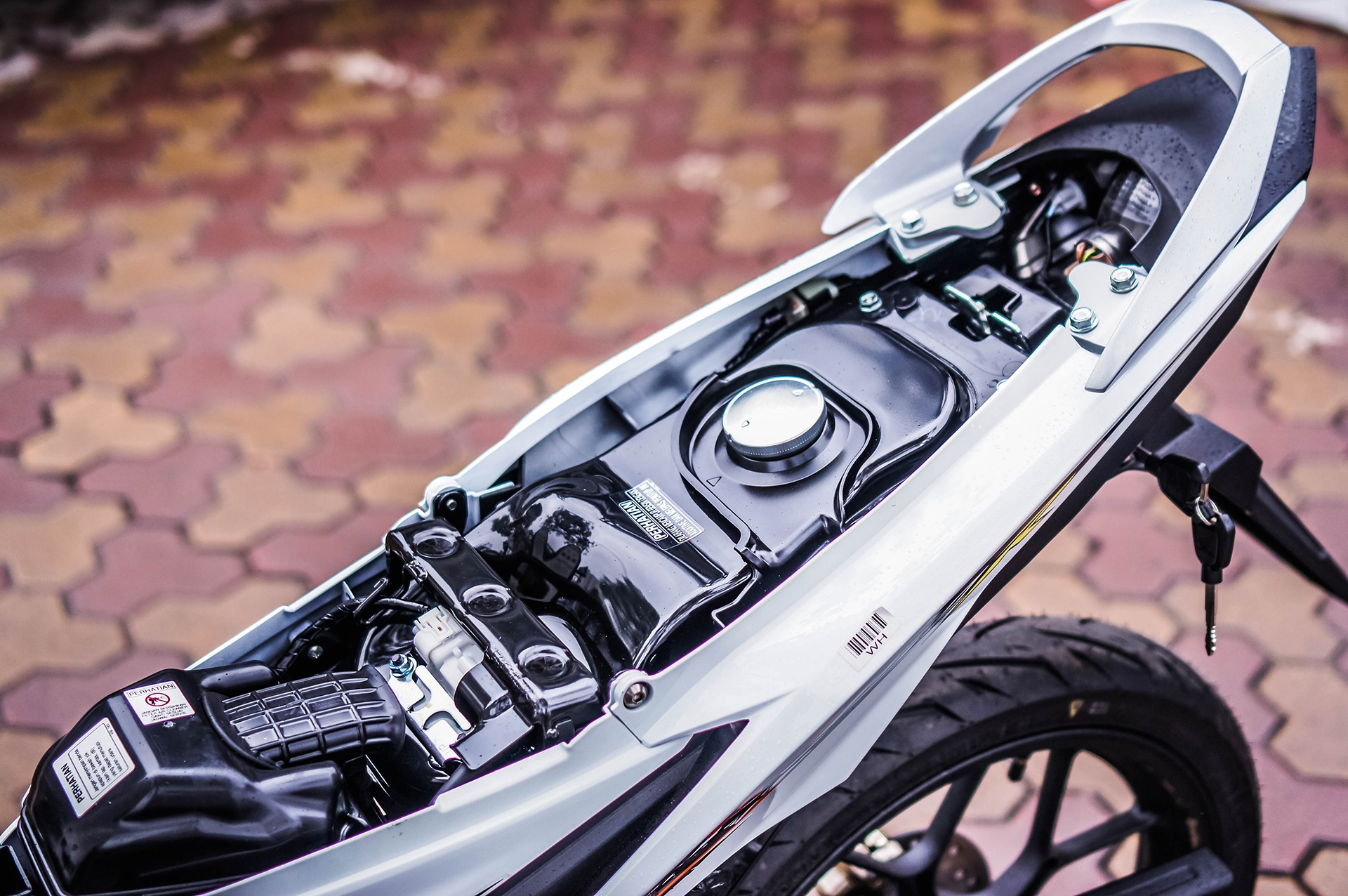 Thiết kế nhỏ gọn của Sonic khiến bên dưới yên chỉ có vị trí đổ xăng, không có ngăn chứa đồ. Vị trí khoá mở yên cũng tách rời với cụm khoá chính. 