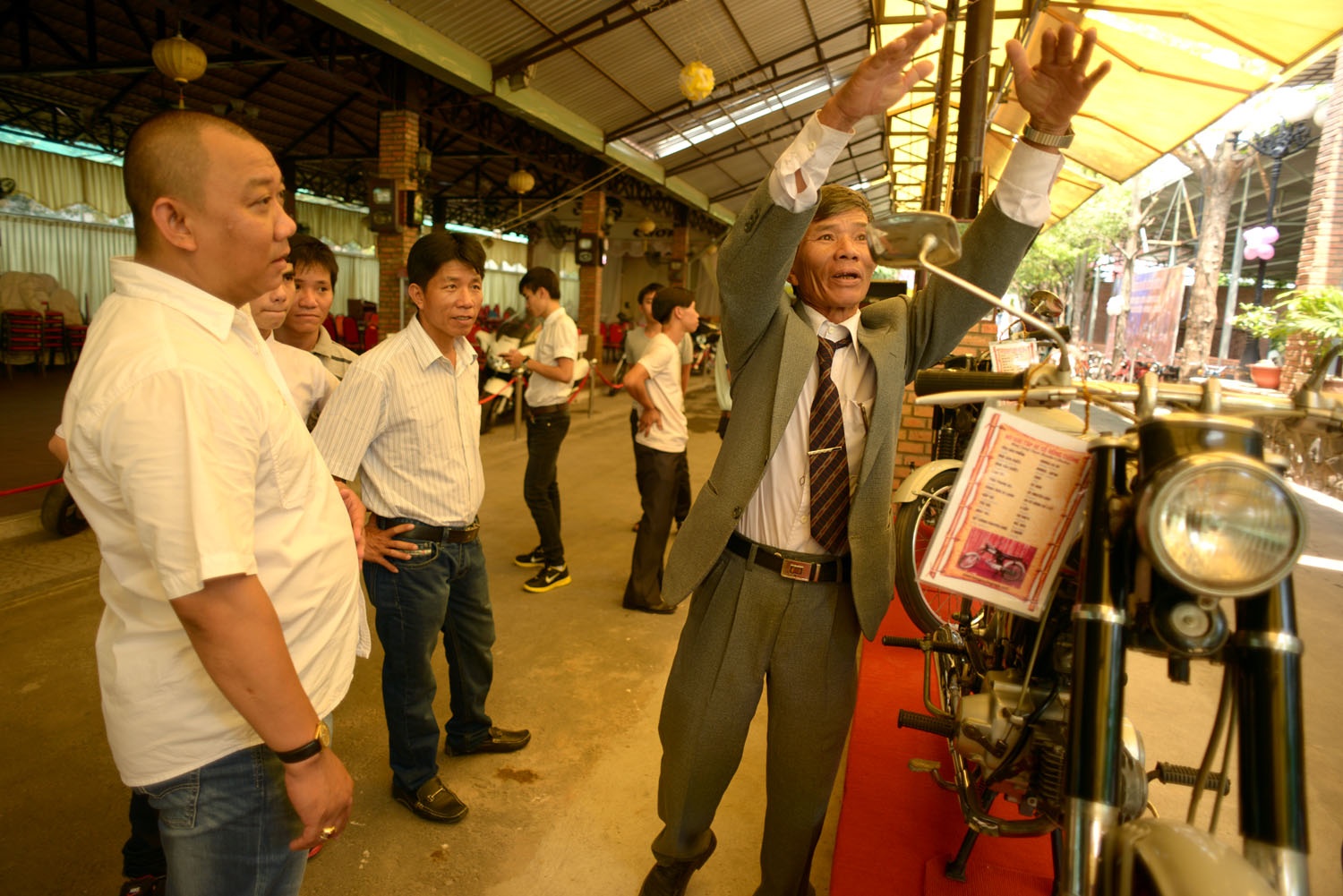 Một khách thăm quan ở Bình Định trao đổi với Nguyễn Tuấn Cường về chiếc xe Honda 67 mà ông đã từng sở hữu nhiều năm.