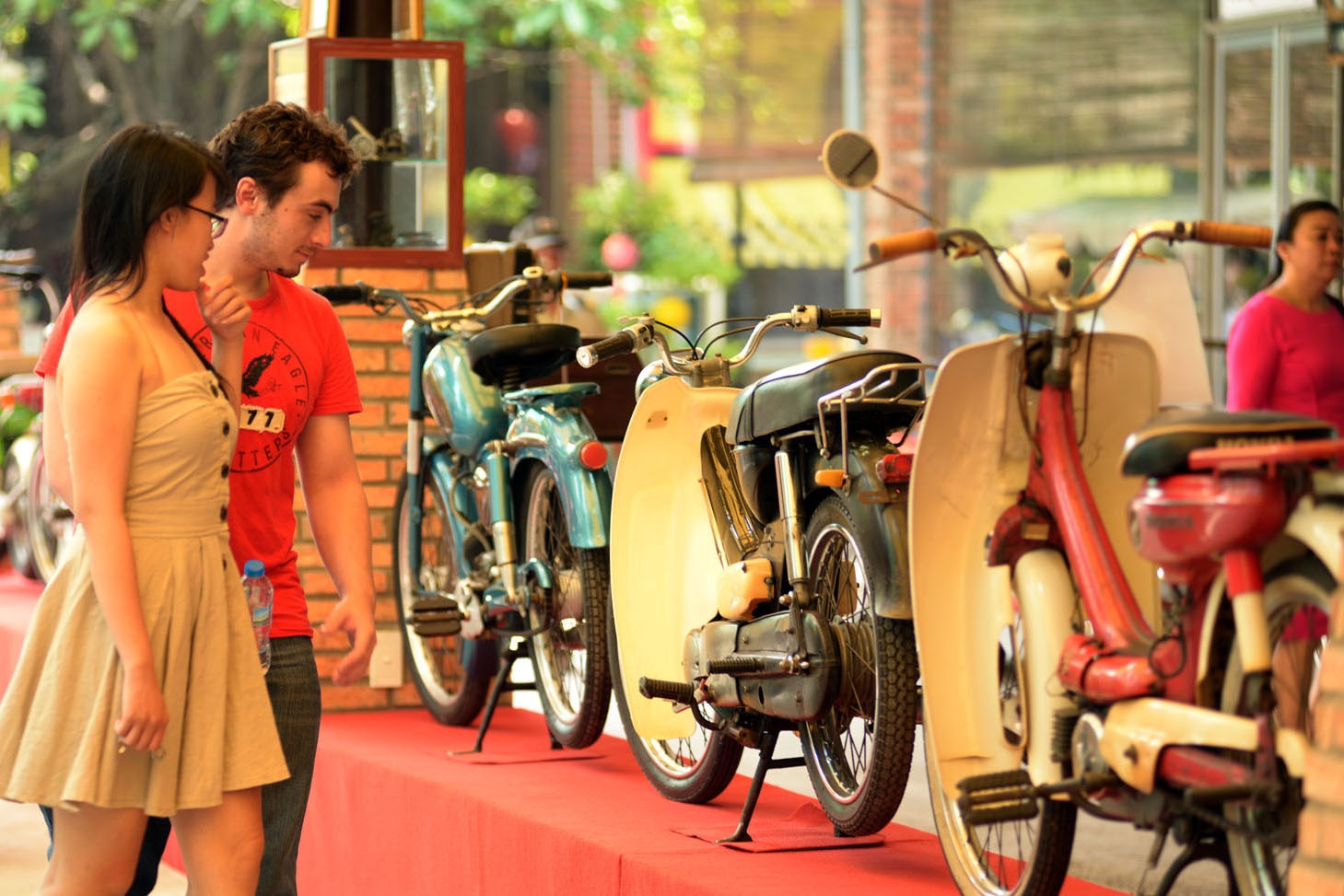 Một khách nước ngoài thích thú khi đi ngắm những chiếc xe cổ.