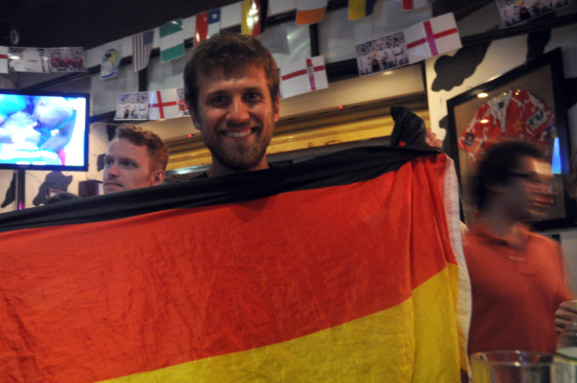 Một người đàn ông mang theo lá cờ 3 màu của đất nước tới quán, chờ Đức dành chiến thắng để ăn mừng cùng bạn bè.