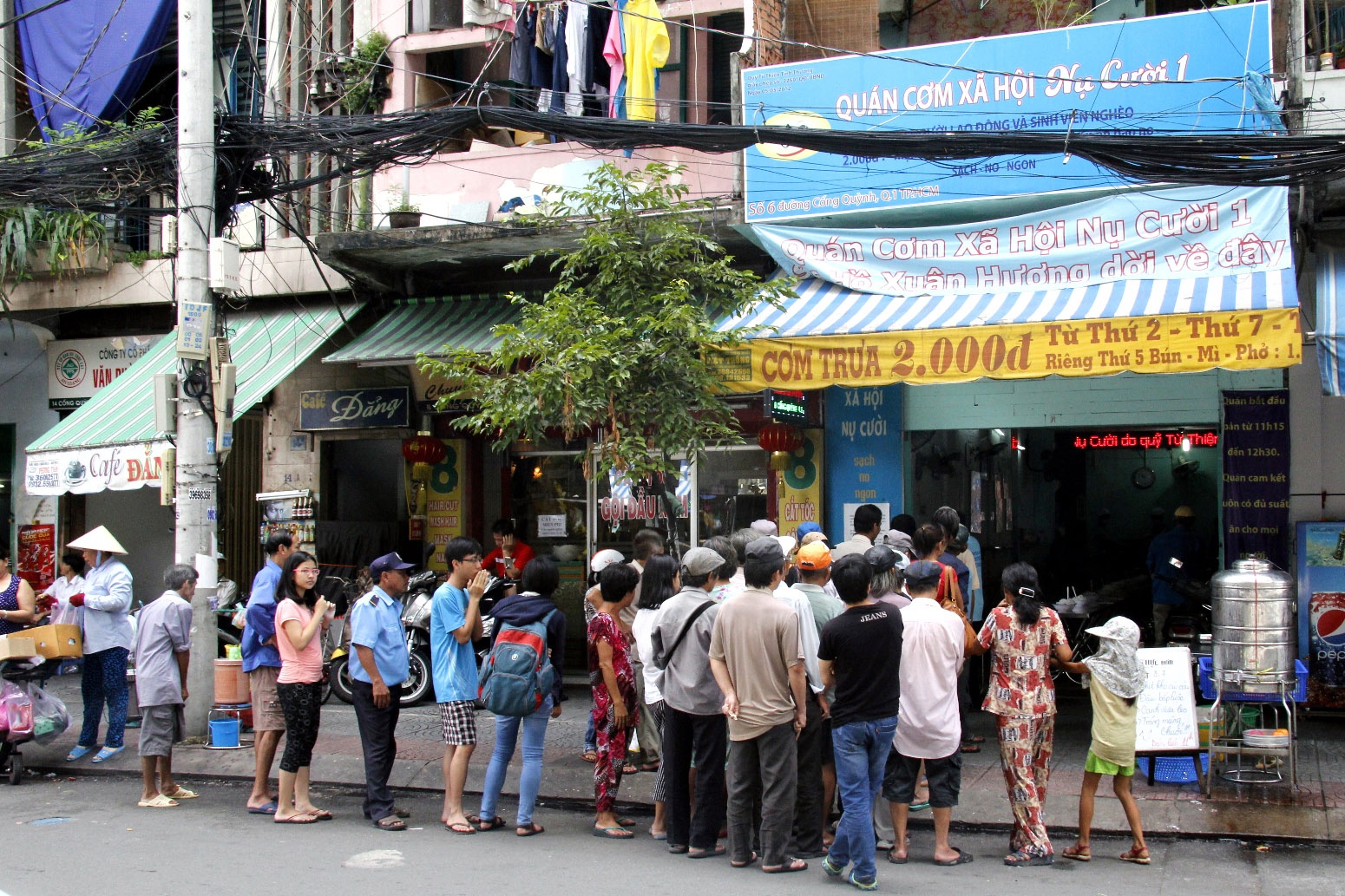 Gần 11g bắt đầu đông khách đến xếp hàng. Gồm rất nhiều thành phần khác nhau, song chủ yếu là người lao động nghèo bán vé số, bán báo, chạy xích lô, xe ôm, lượm bọc nilon.