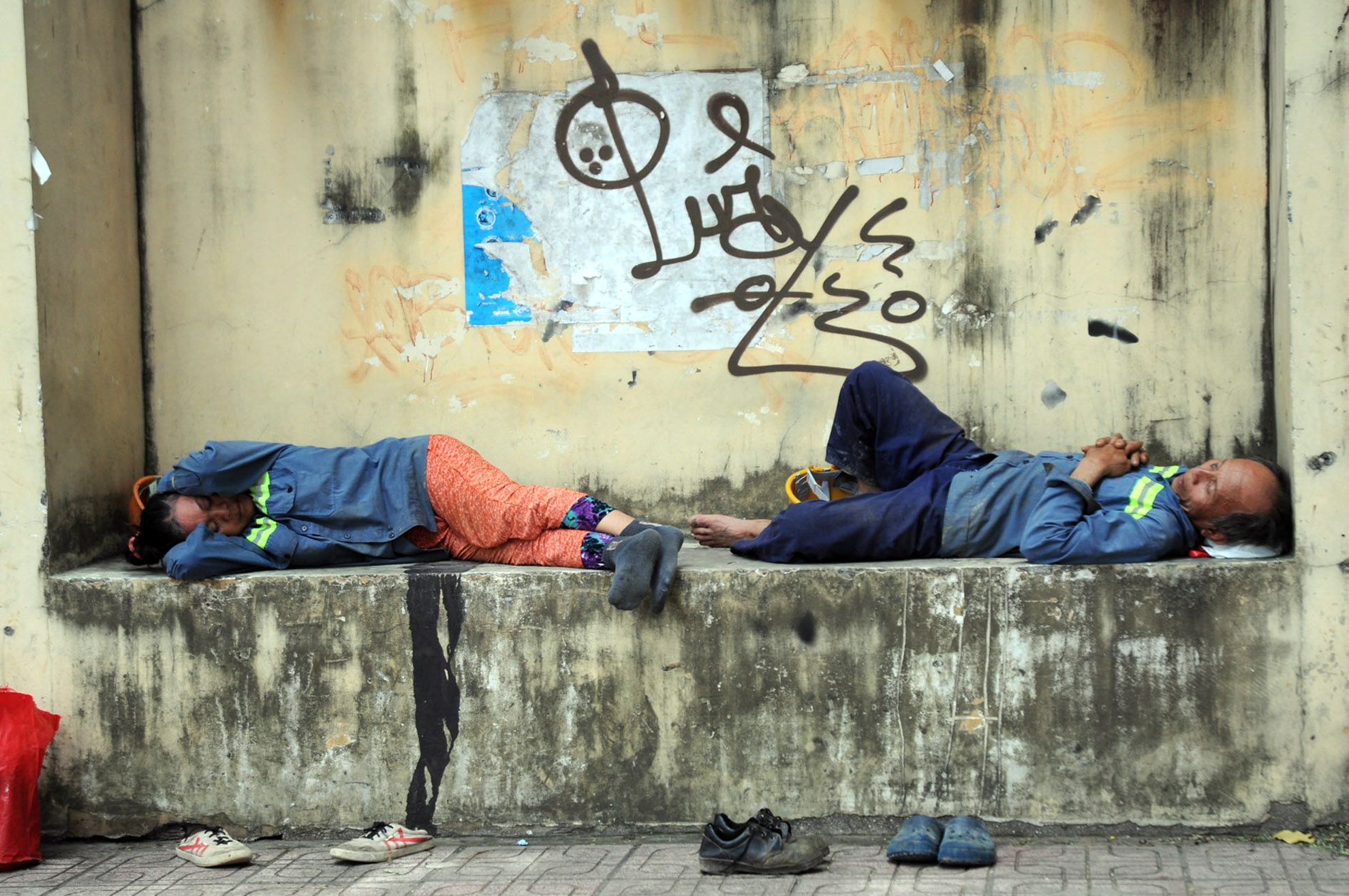 Hai công nhân lớn tuổi làm việc ở công trường trên đường Võ Văn Tần (quận 3) tranh thủ ngủ để có sức làm ca chiều.