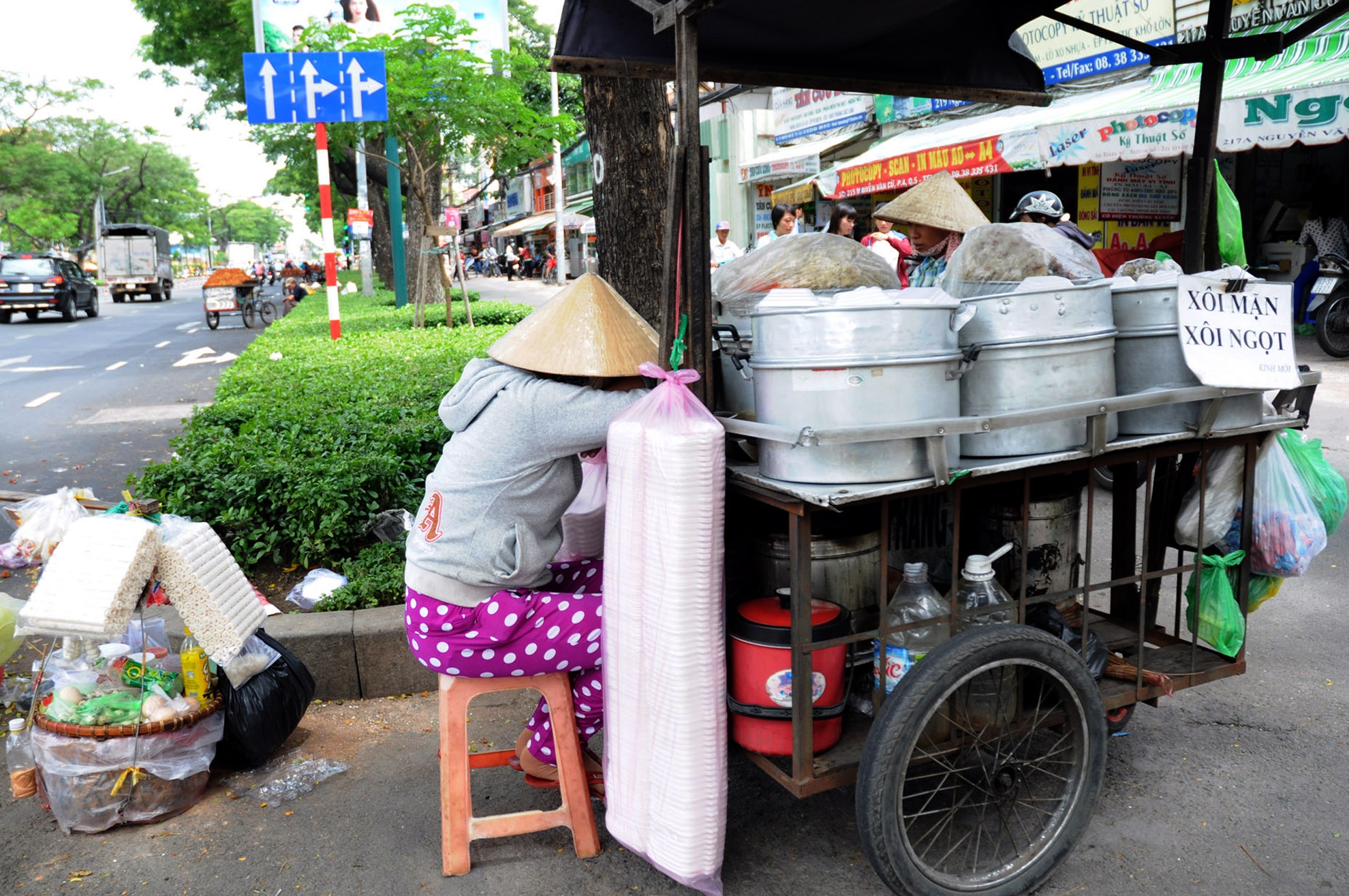 Trong khi đó, chị bán xôi tựa đầu vào xe ngủ gật để chờ khách mua hàng.