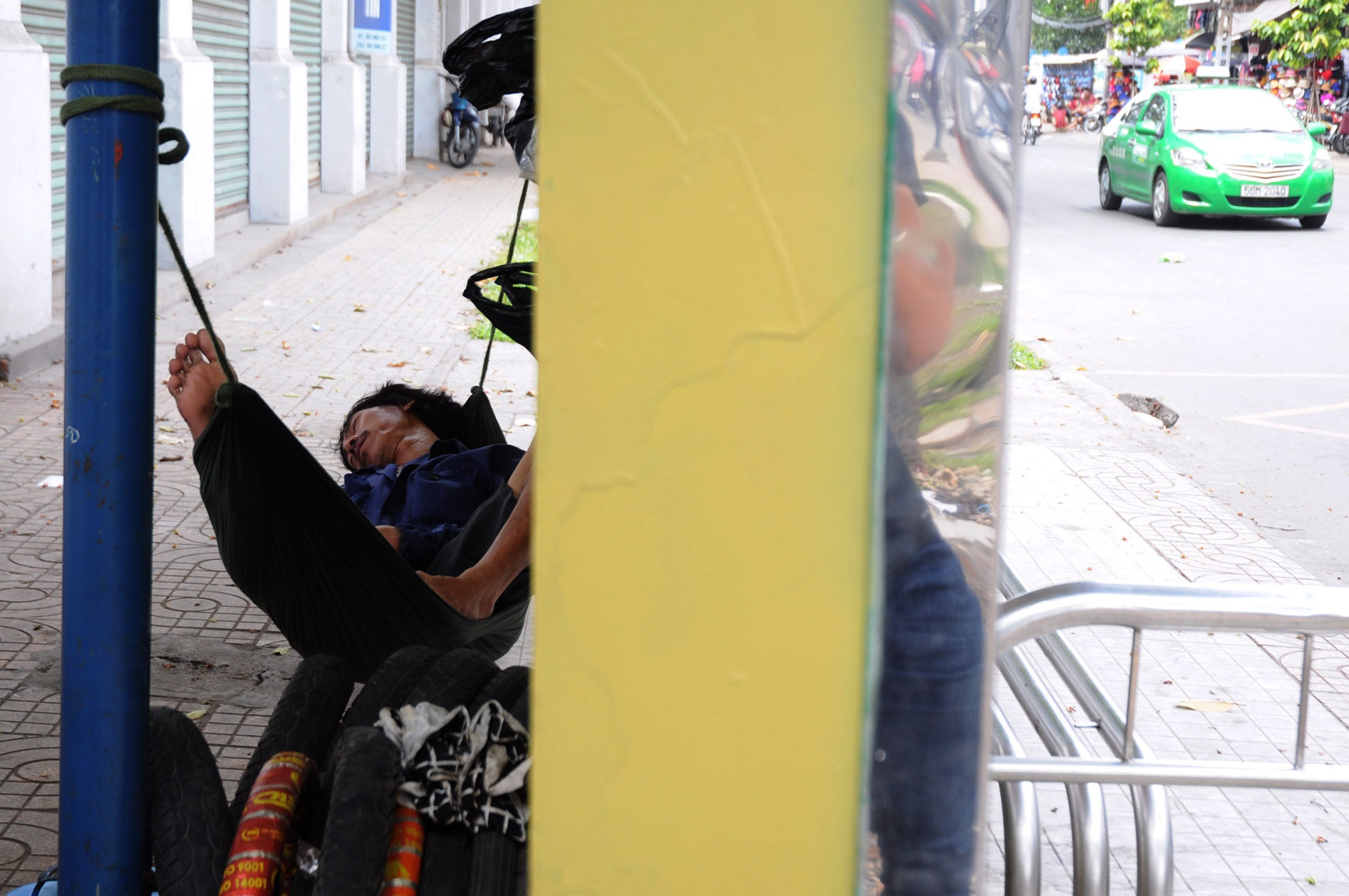 Mặc cho dòng xe đông đúc đang chạy ngoài đường, anh sửa xe đạp tìm cho mình một nơi yên tĩnh để ngã lưng.