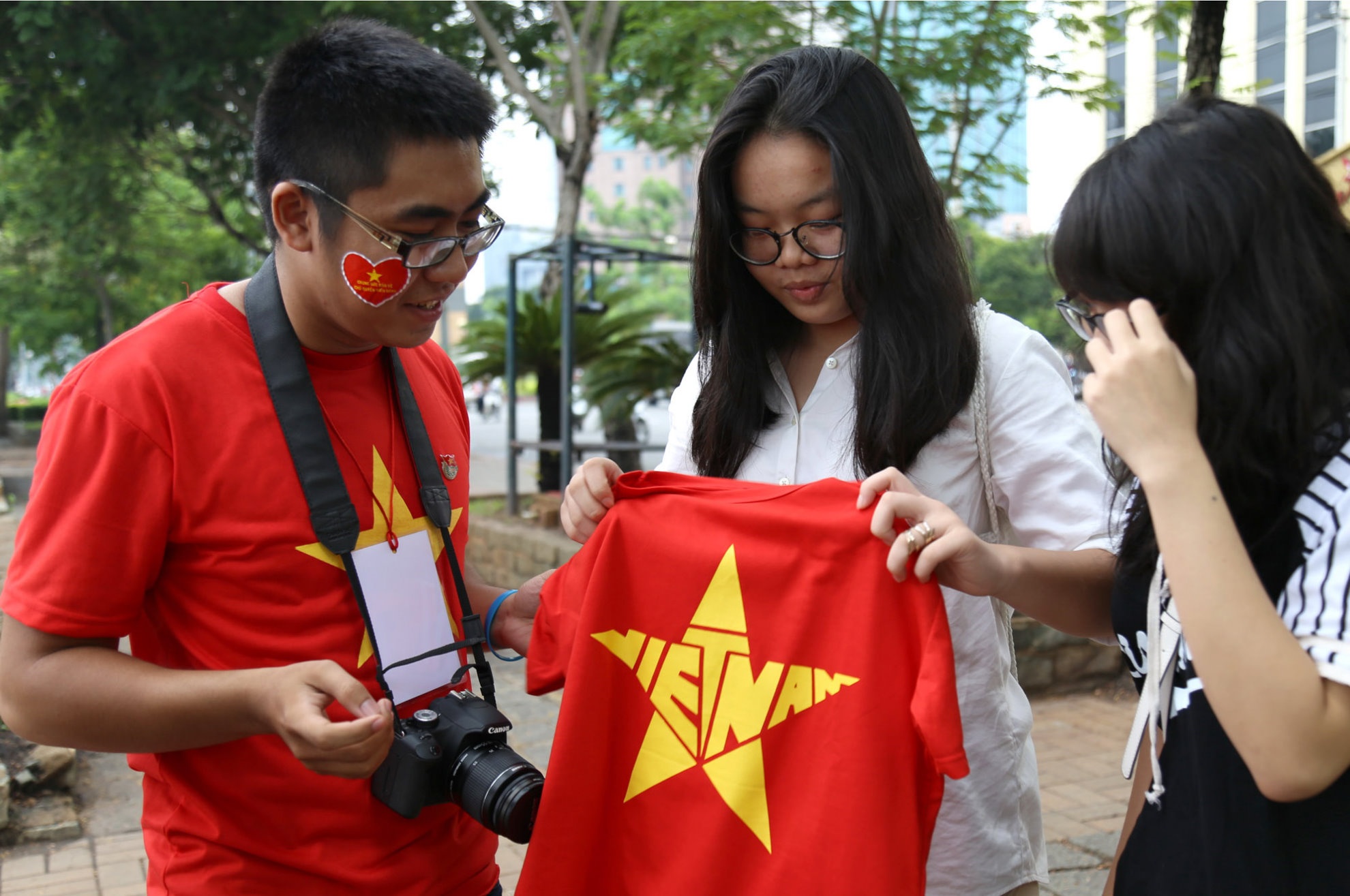 Một bạn trong nhóm đang giới thiệu chương trình “Tự hào ngôi sao VN” cho 2 bạn thanh niên người Hàn Quốc và mời các bạn tham gia chụp ảnh với áo cờ nước tại điểm chụp bến Bạch Đằng.