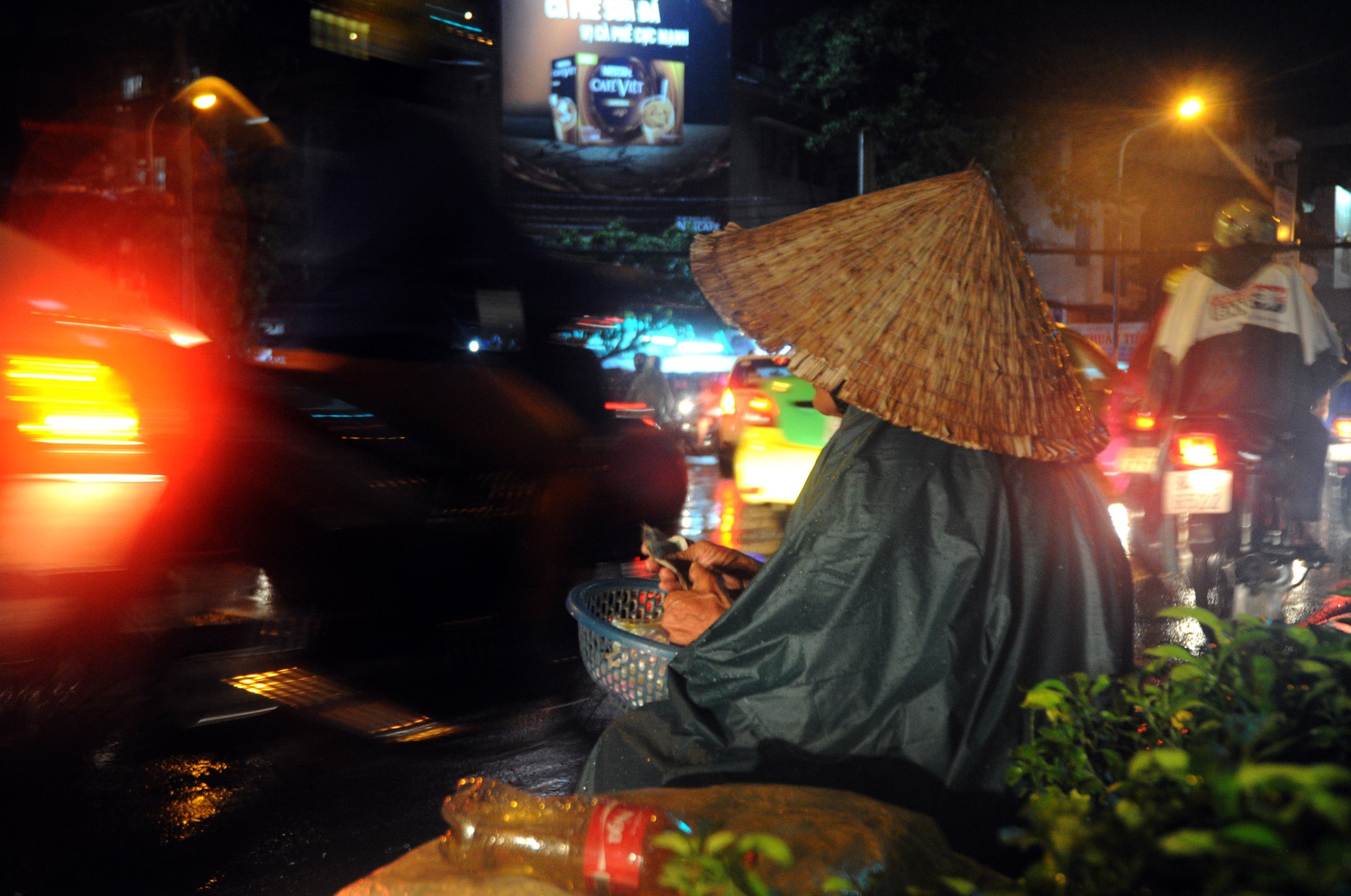 Bà cụ năm nay đã ngoài 70 tuổi, mắt không còn nhìn thấy vẫn ngồi bán bông tăm trong đêm mưa ở ngã tư Nguyễn Trãi-Nguyễn Văn Cừ (quận 5).