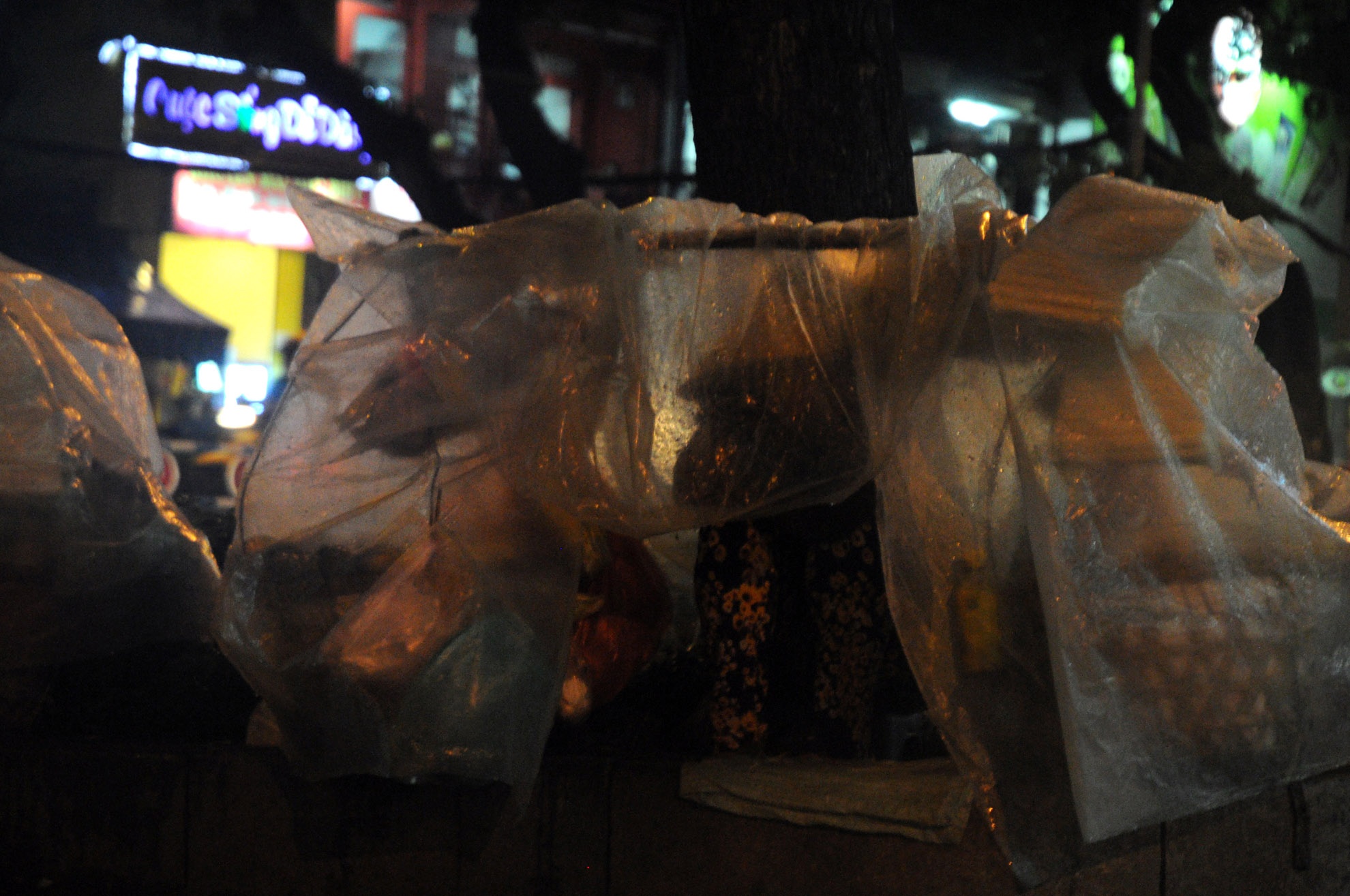 Trời mưa khiến việc buôn bán cũng trở nên khó khăn, ế ẩm hơn ngày thường. Trong ảnh: Người phụ nữ bán hang rong trên đường Nguyễn Văn Cừ (quận 5) đang ngồi trong mưa chờ khách mua hang.
