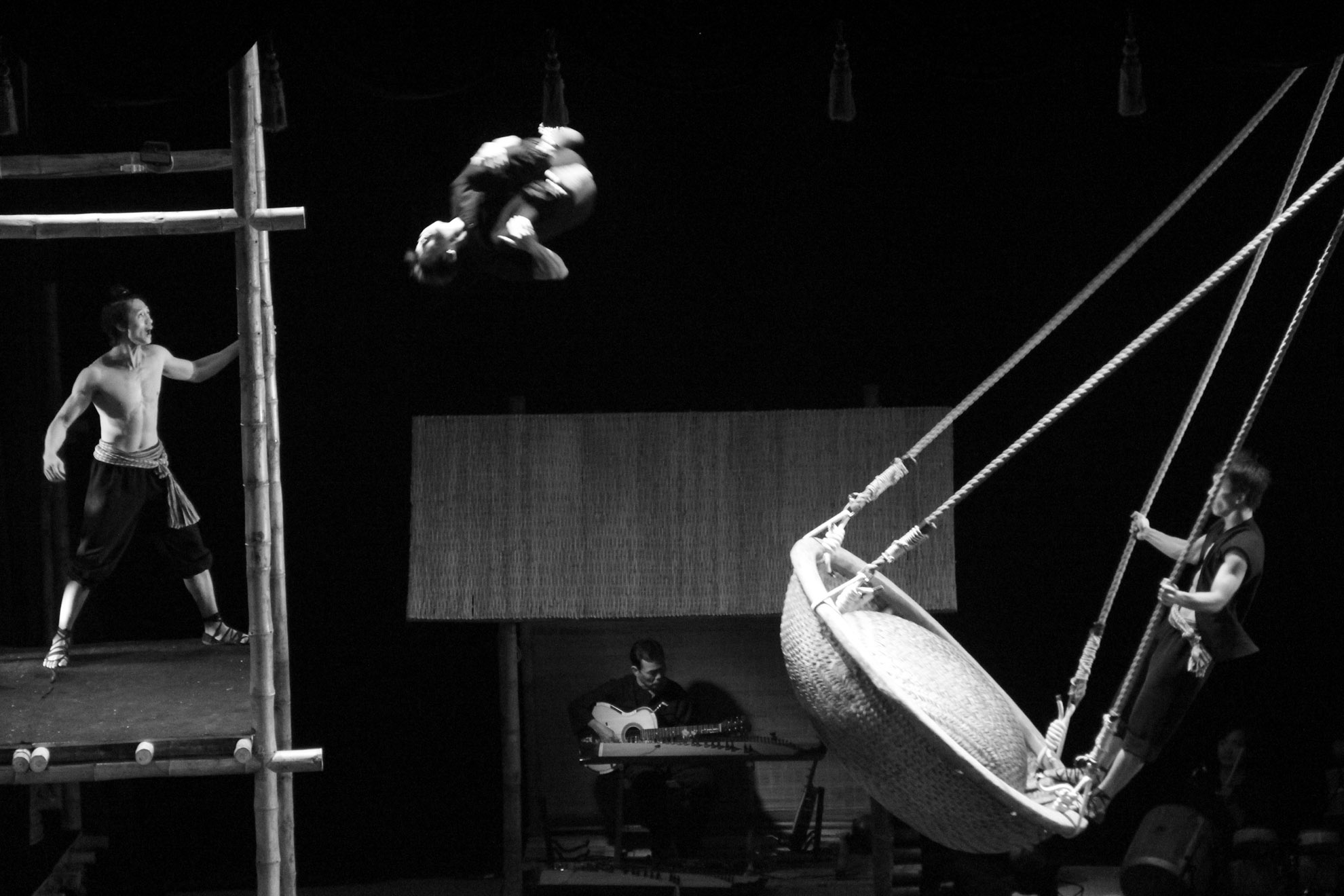 Phân cảnh đu và nhào lộn với thúng và giàn cao có lẽ là phân cảnh ấn tượng nhất. “Xích đu thúng” được treo cao cách mặt đất khoảng 2m, và các diễn viên phải bay từ thúng qua dàn cao cách mặt đất hơn 4m. Các động tác này được các diễn viên tập luyện hàng ngàn lần. Ở màn trìn diễn này đòi hỏi sự phán đoán chuẩn xác và tập trung cao độ của cả người nhảy và người hỗ trợ để xử lý tốt khi có sự cố.