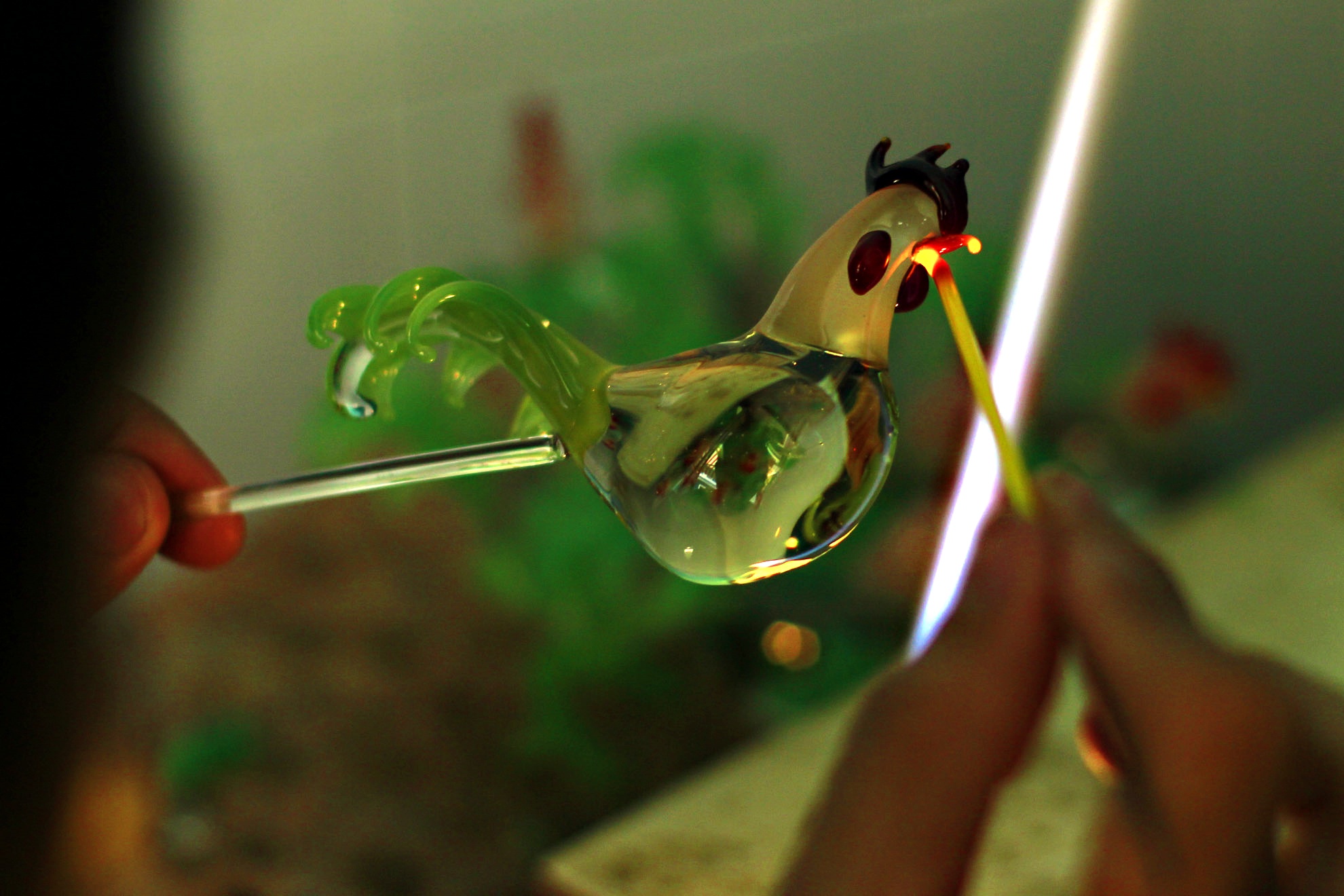 Và rồi một chú gà xinh xắn đã xuất hiện, anh thoăn thoắt thay đổi những thanh màu khác nhau đển tạo mắt, mào cánh cho chú gà. Anh chia sẻ phải làm thật nhanh và thật đều vì chỉ cần nhiệt độ không phù hợp thủy tinh sẽ mất độ kết dính và vỡ ngay.