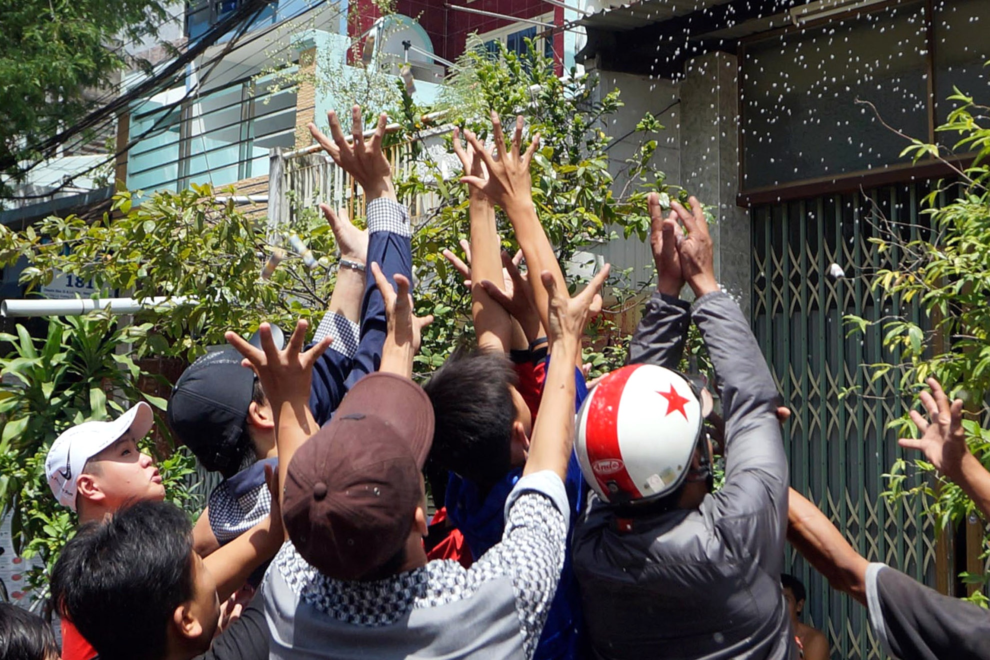 Họ chờ cho các gia đình cúng xong, tung tiền, đồ ăn để giành giật cho mình.