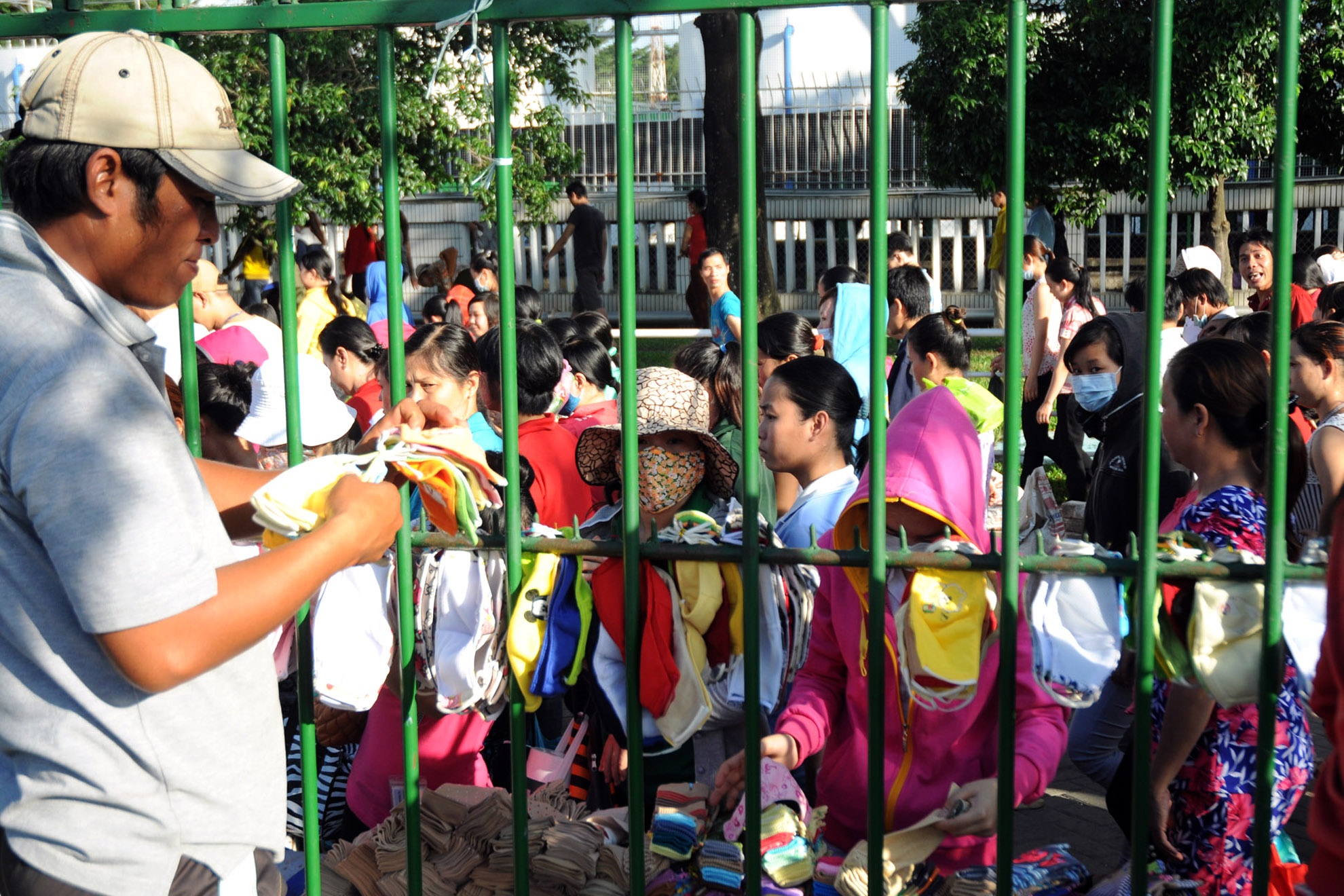 : Khách hàng của “chợ” đặc biệt này đều là những công nhân. Cứ mỗi chiều tan ca, họ lại tụ tập lại hàng rào để mua đồ.