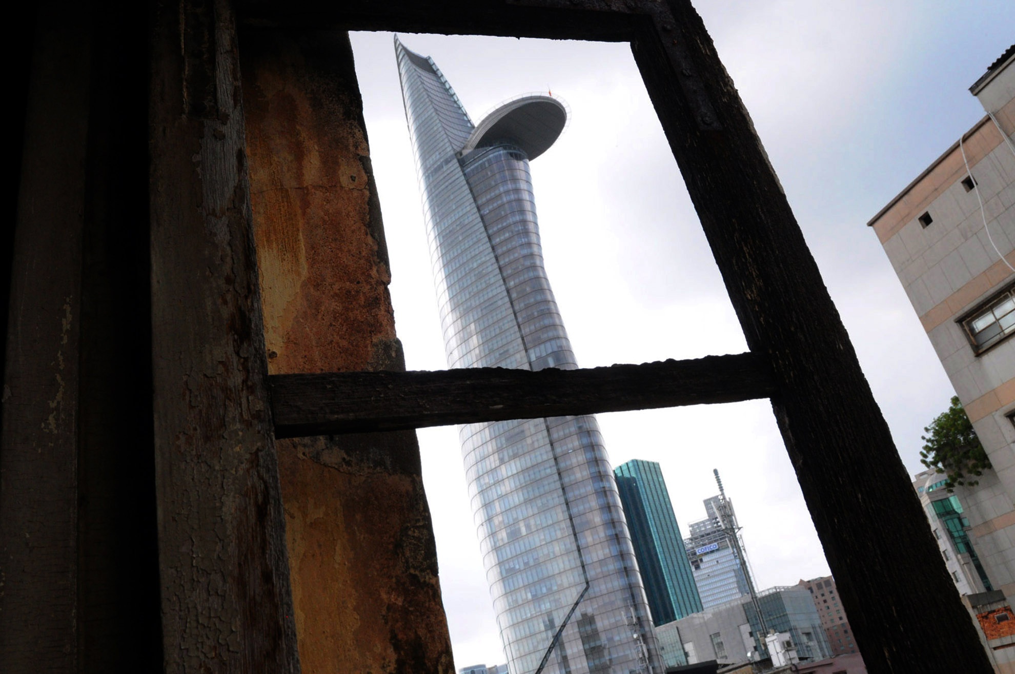 Nhiều người thích nhìn toà tháp Hoa Sen qua một khung cửa gỗ trăm tuổi, quá khứ và tương lai của Sài Gòn hiện ra chỉ trong  một khuôn hình.