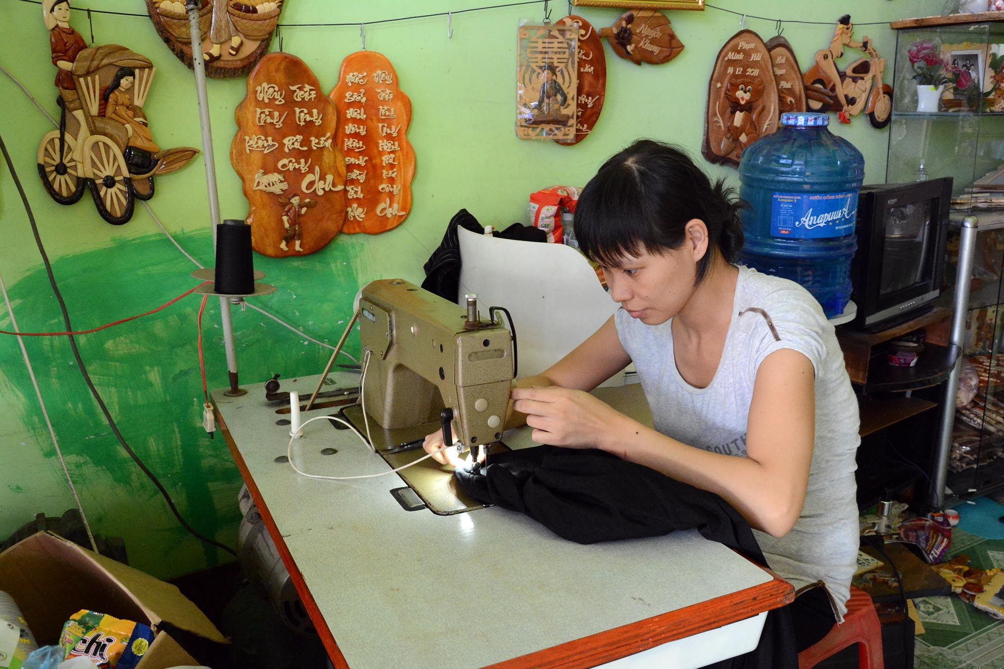 Chị Thủy, vợ anh Út hằng ngày ở nhà làm công việc may vá, và trông coi cửa hàng để kiếm thêm thu nhập, trang trải cuộc sống.