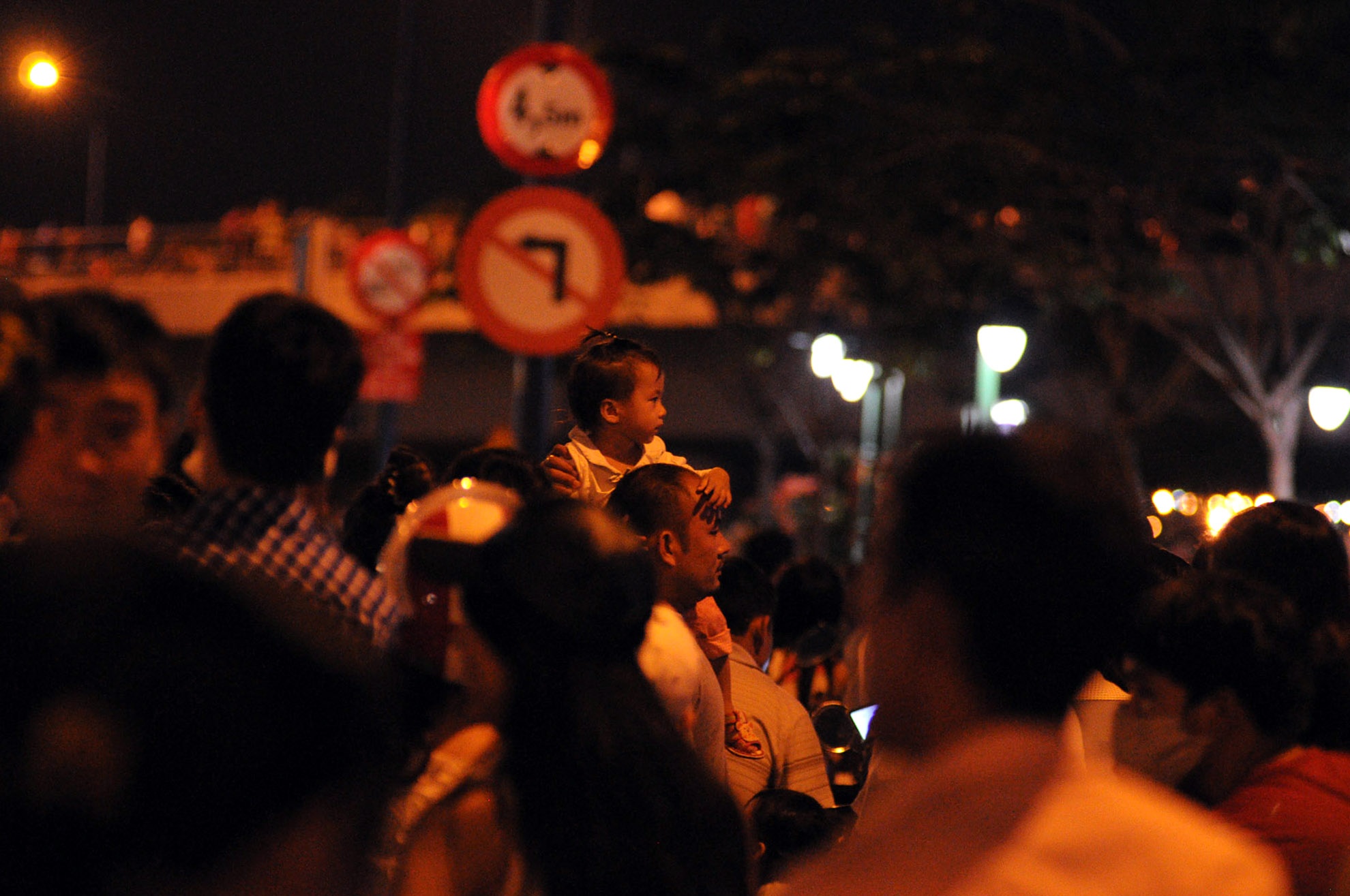 Các bé được người lớn cho ngồi lên cao để xem pháo hoa cho rõ.