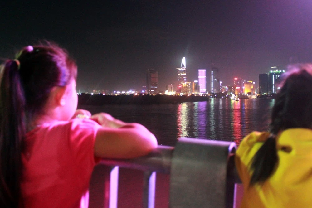 Từ góc nhìn này, các bé có thể thấy đêm hội pháo hoa lung linh trên nền thành phố hiện đại, rực rỡ.