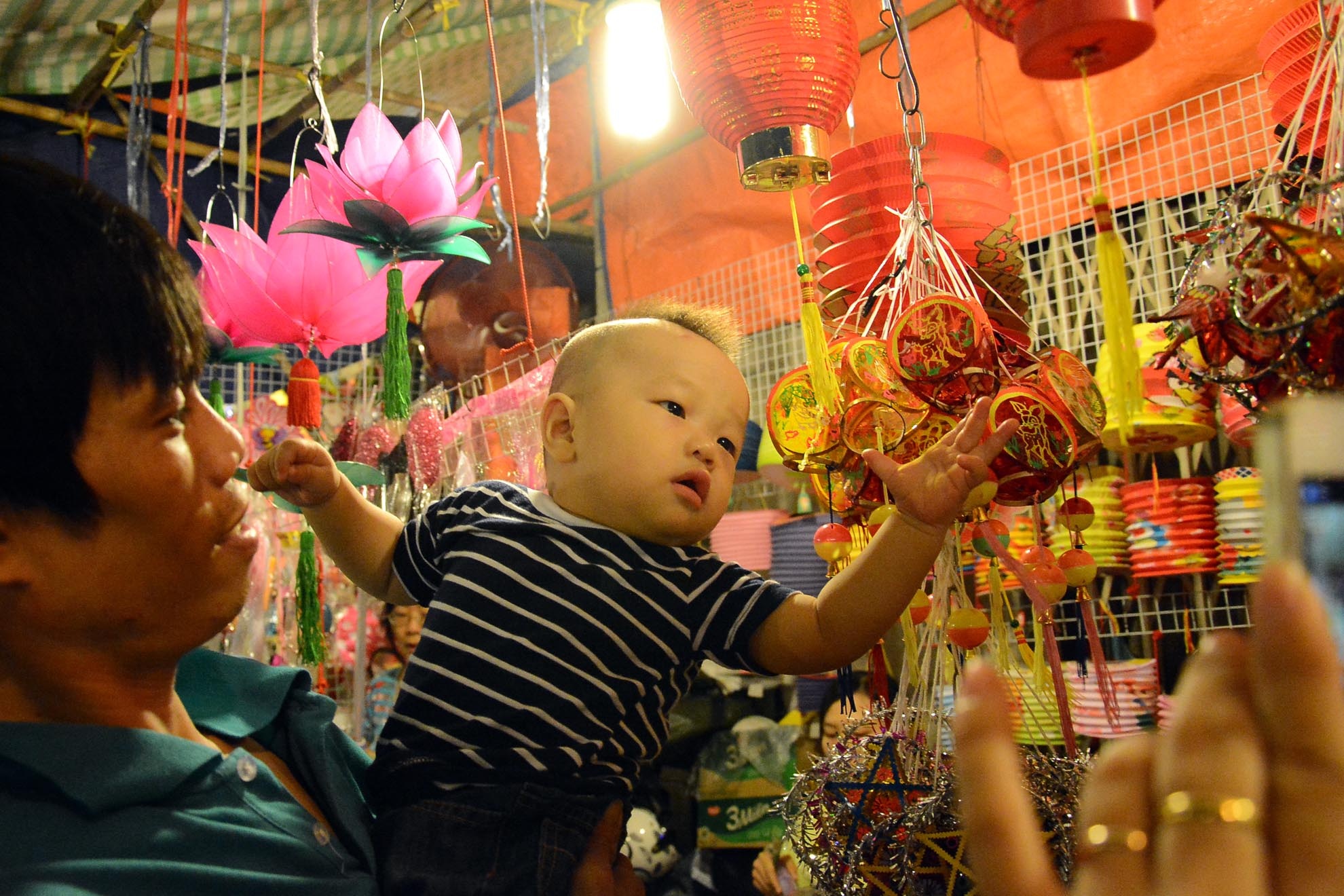 Có thể cậu bé này chưa hiểu gì về ý nghĩa của chiếc lồng đèn và tết trung thu nhưng được chạm vào những chiếc đèn lồng nhiều màu sắc, lung linh, huyền ảo là hết sức thích thú và đáng nhớ.