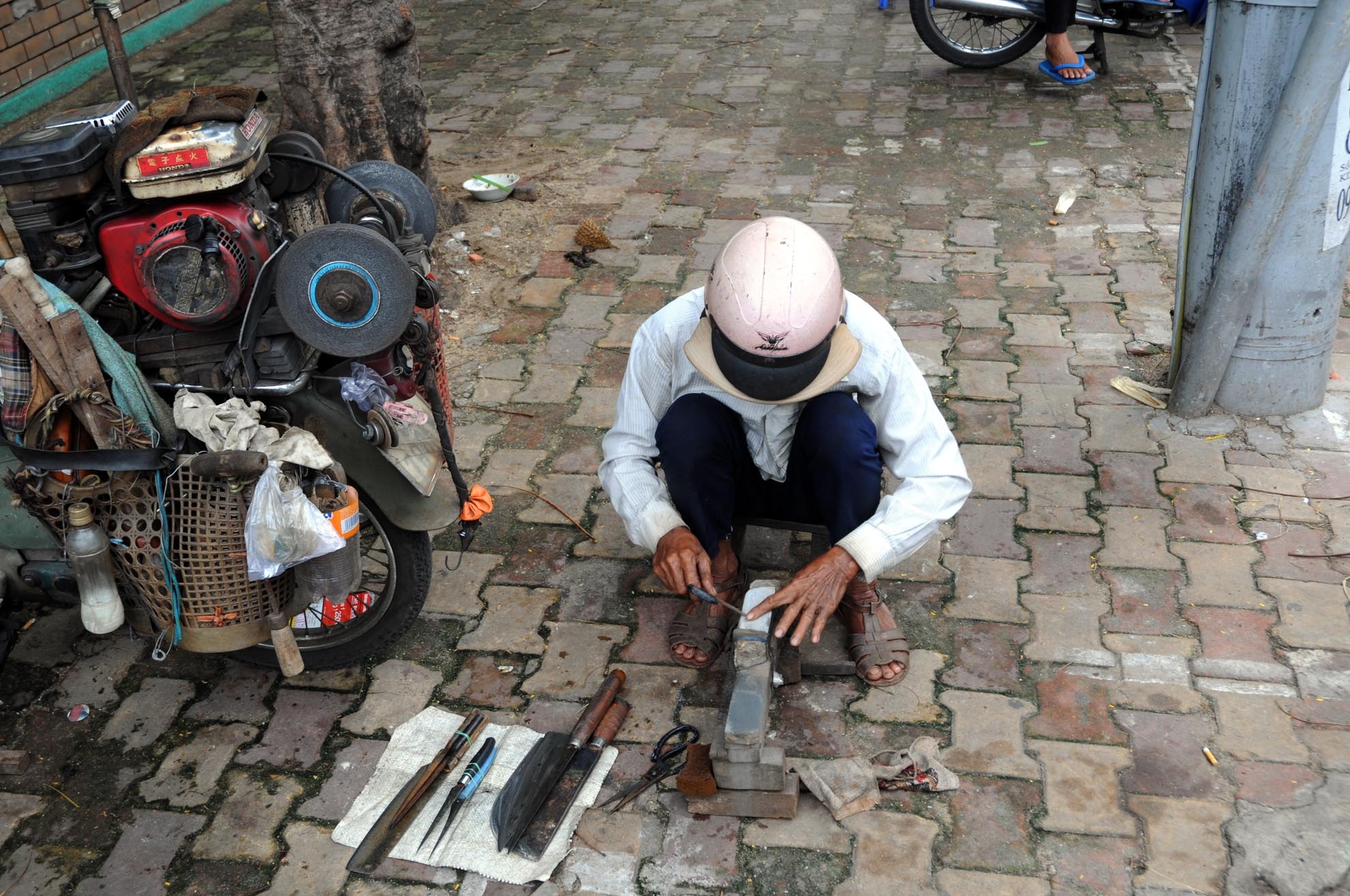 Đồ nghề của một thợ mài dao kéo cũng khá đơn giản. Ngoài chiếc xe máy cà tàng để di chuyển, họ chỉ cần thêm bộ máy mài, mấy hòn đá là có thể làm nghề tốt. “Làm nghề này quan trọng là bộ mài dao, nếu tốt thì mài dao kéo sẽ sắc ngọt”. Ông Thanh cho biết.