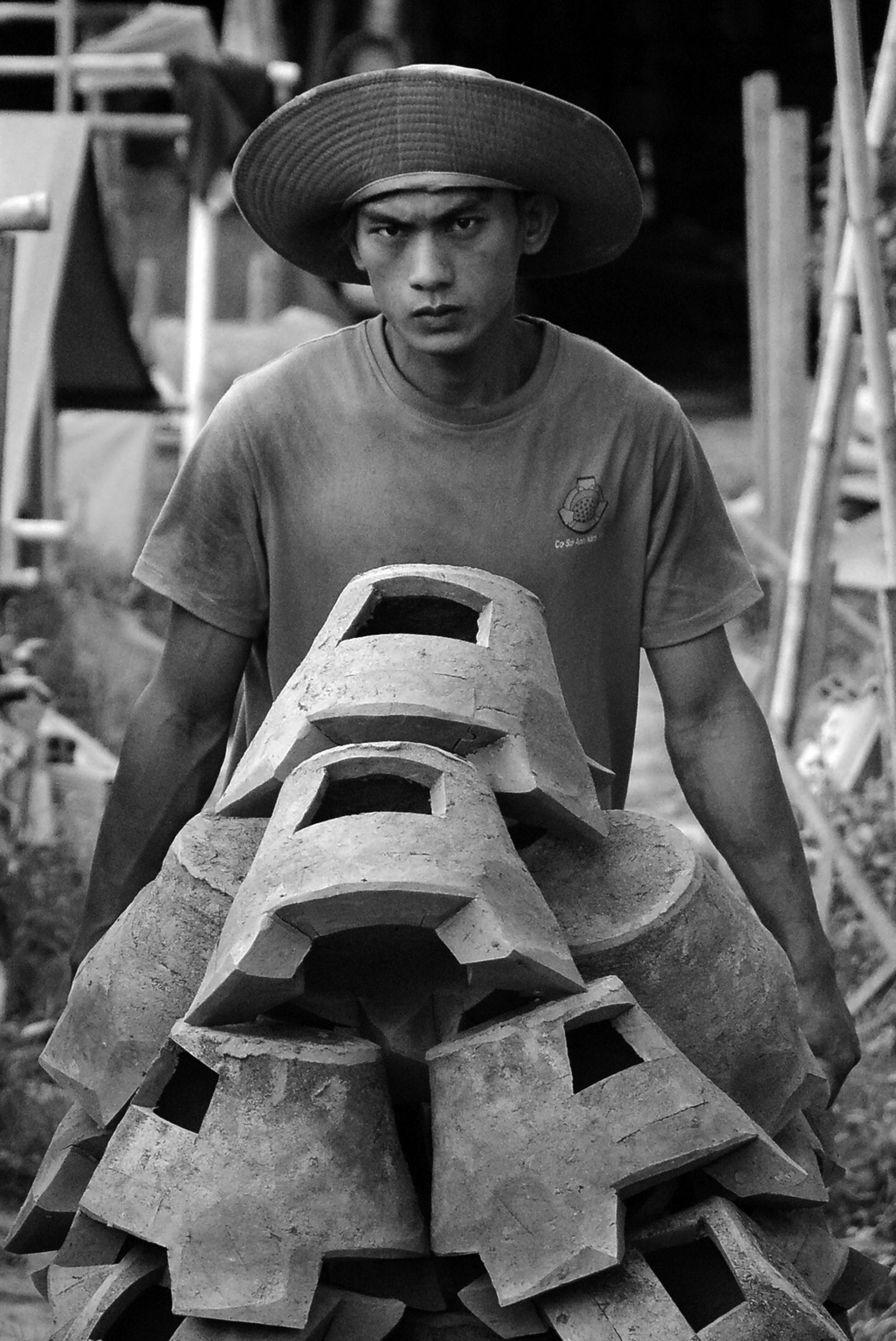 Cường em (25 tuổi) cùng các thợ phụ trẻ tuổi khác có sức khoẻ, thường làm những công việc nặng nhọc như nhào trộn đất, phơi, bốc vác, vận chuyển sản phẩm.