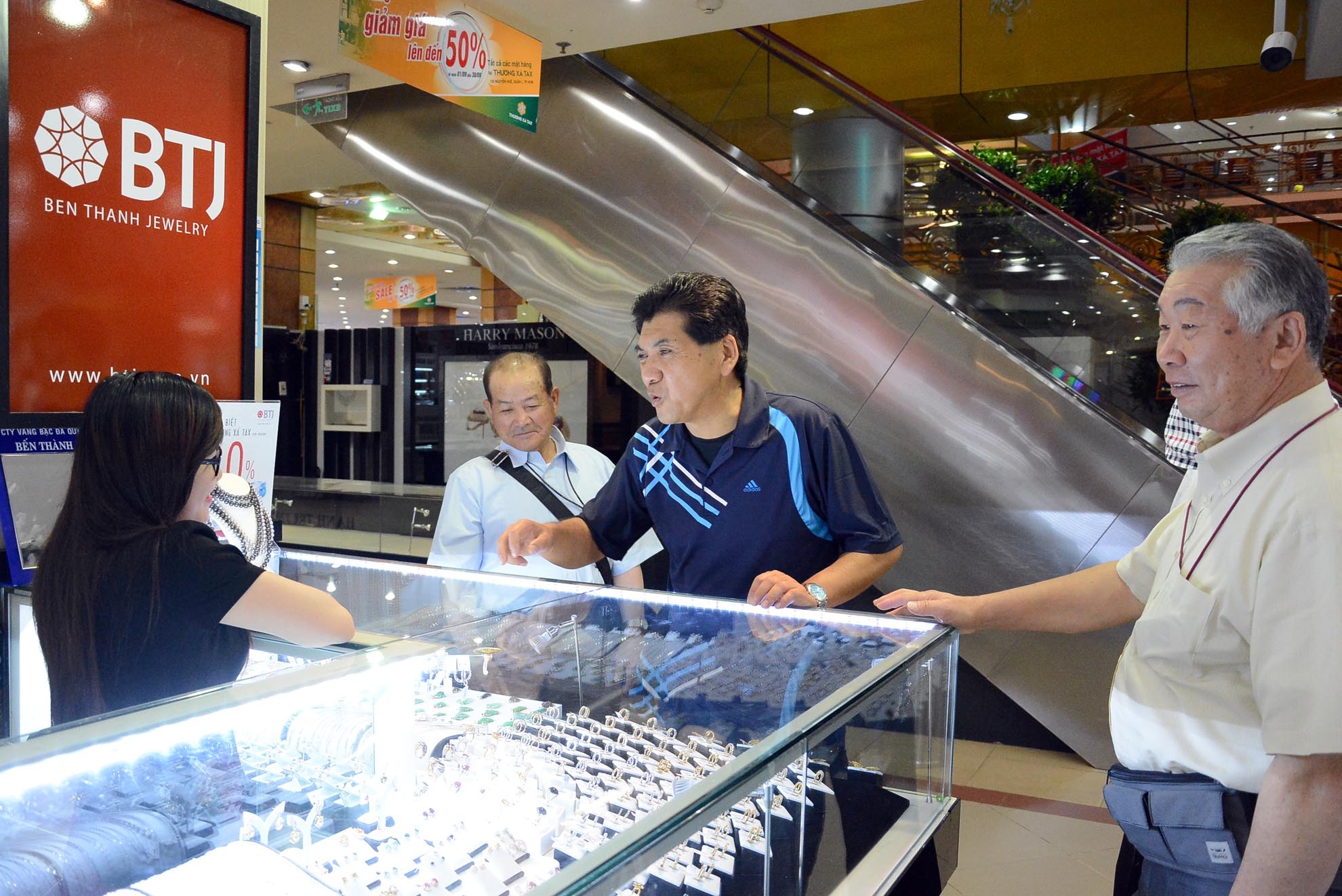 Những vị khách nước ngoài mua hàng giảm giá lần cuối tại một quầy hàng kinh doanh vàng.