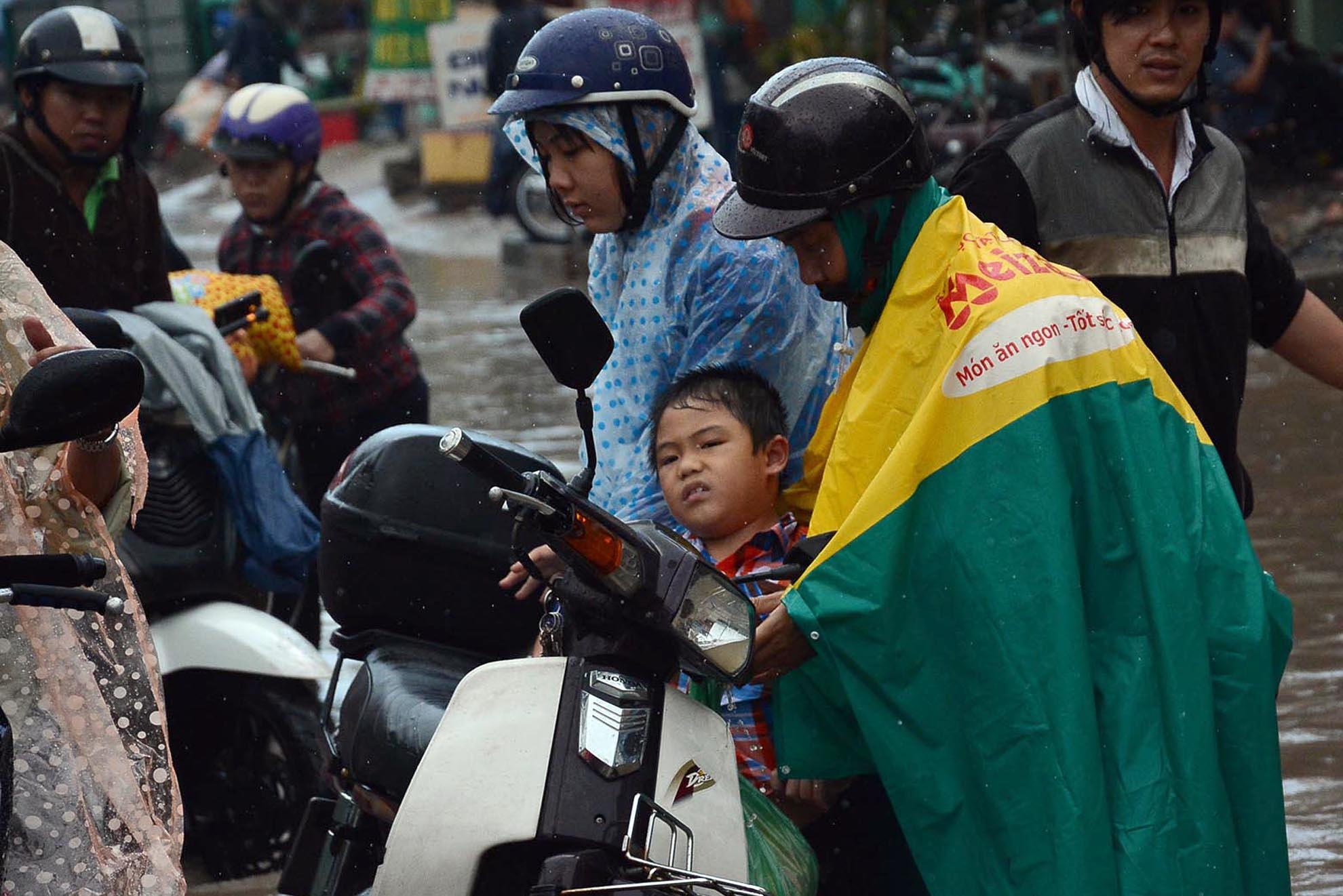 Be trai suyt ngat xiu khi di tren con duong ngap nuoc hinh anh