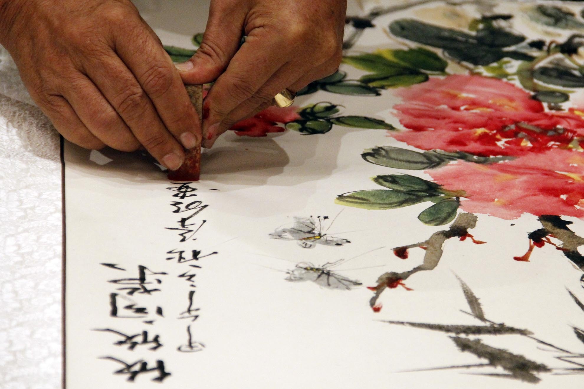 Sau 15 phút, bức Hân Hân hướng vinh đã được hoàn thành.Đề lạc khoản và đóng ấn triện là công đoạn cuối cùng để hoàn thiện bức họa thủy mặc.