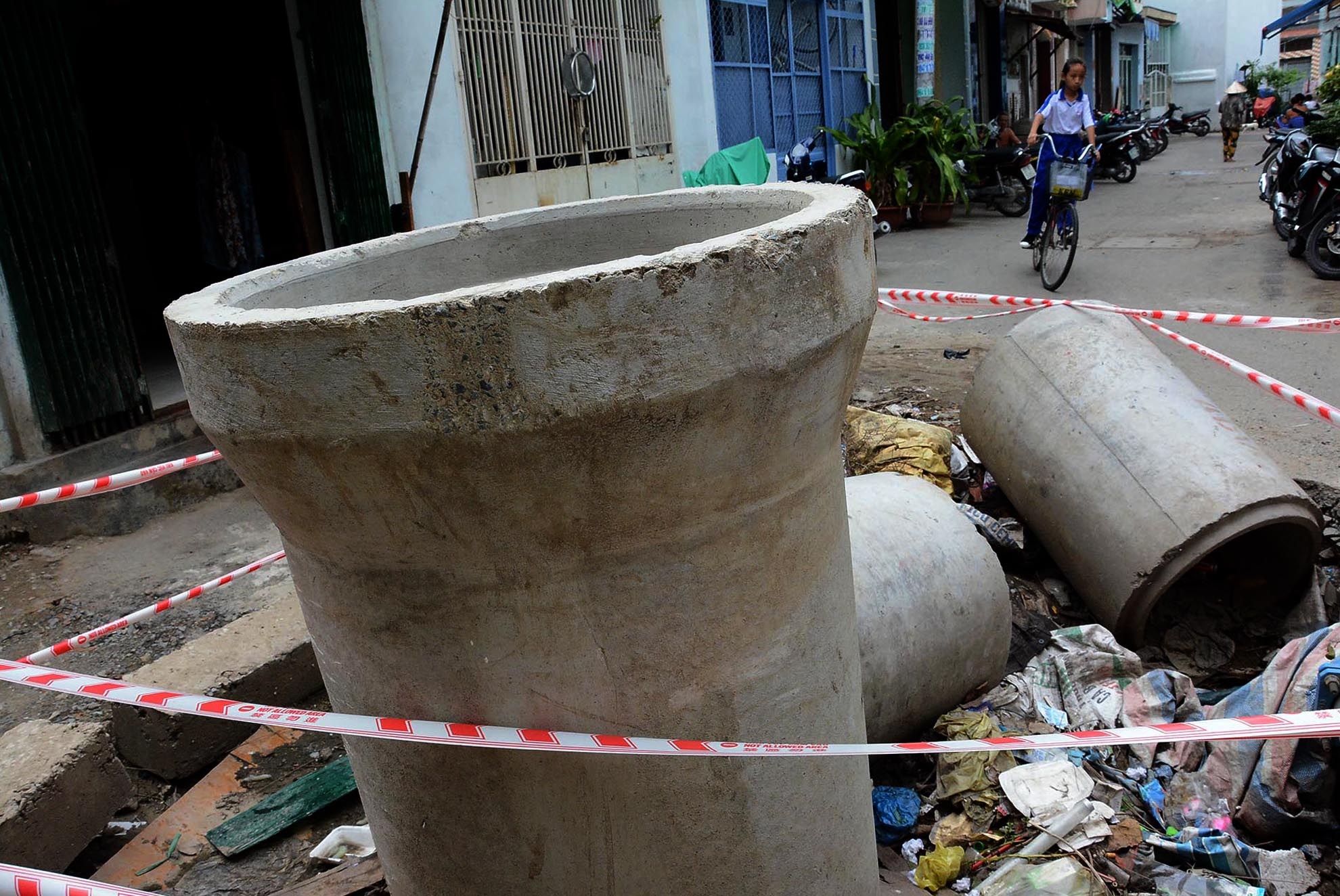 Sau khi người dân bức xúc phản ánh, đơn vị thi công dùng dây nhợ, đóng cọc sơ sài xung quanh hố, nhưng vẫn không đảm bảo an toàn.