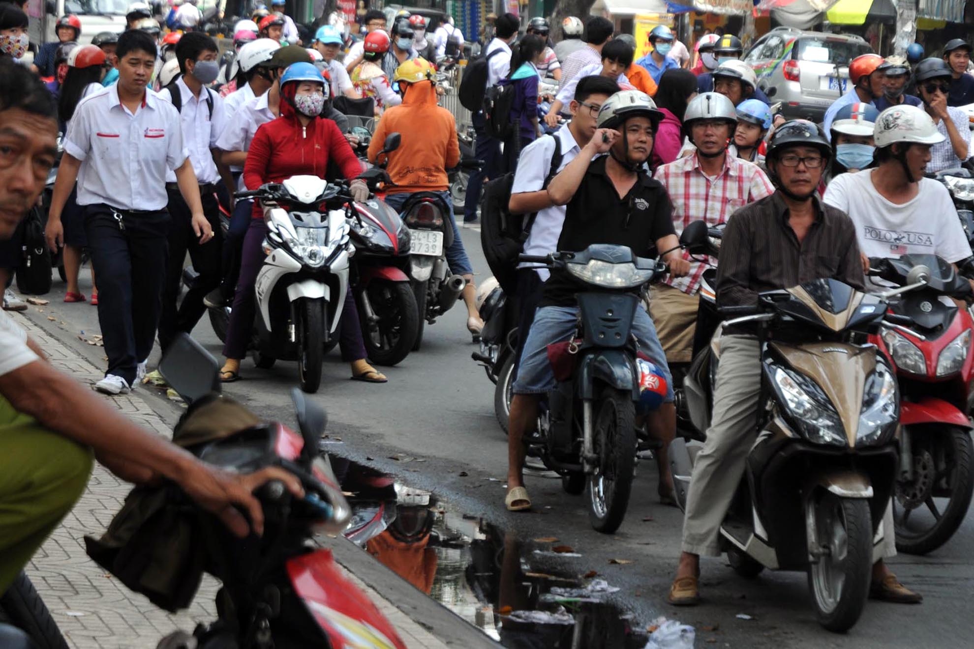 Nhiều phụ huynh đi đón con em không mang theo nón bảo hiểm, không dám vượt qua chốt trạm.