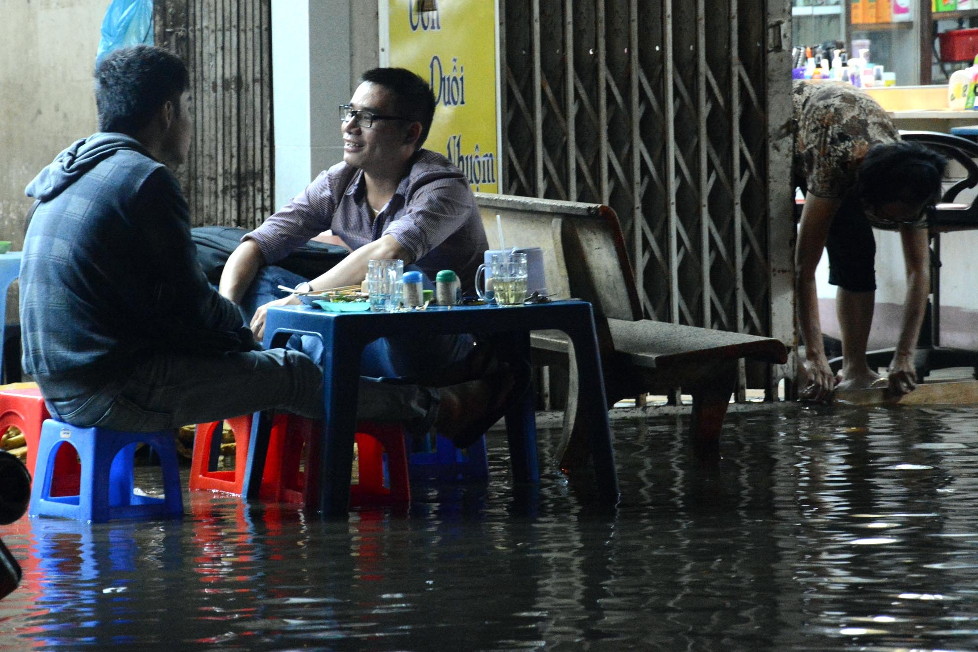 Đã quá quei với cảnh ngập nước, nhiều người ngồi nhậu giữa lênh láng nước ở Thanh Đa.